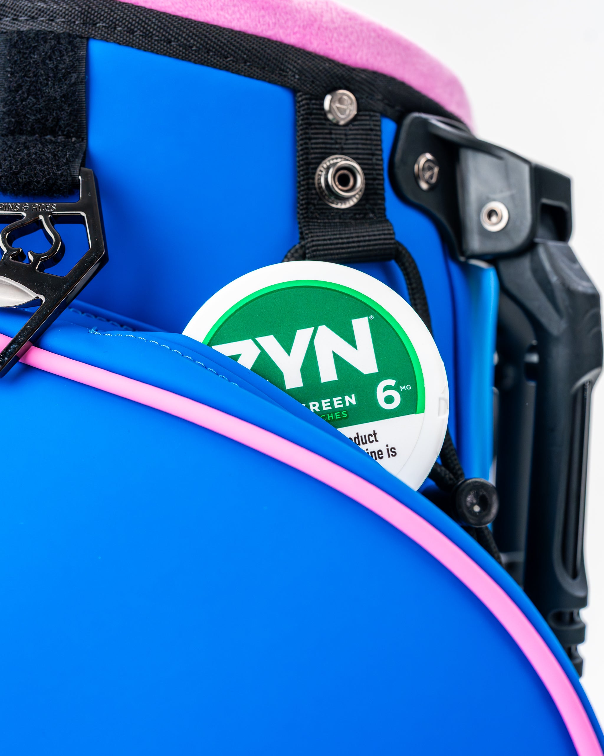 Vibrant blue raspberry golf bag featuring a pink trim and a side pocket holding a can of ZYN product.