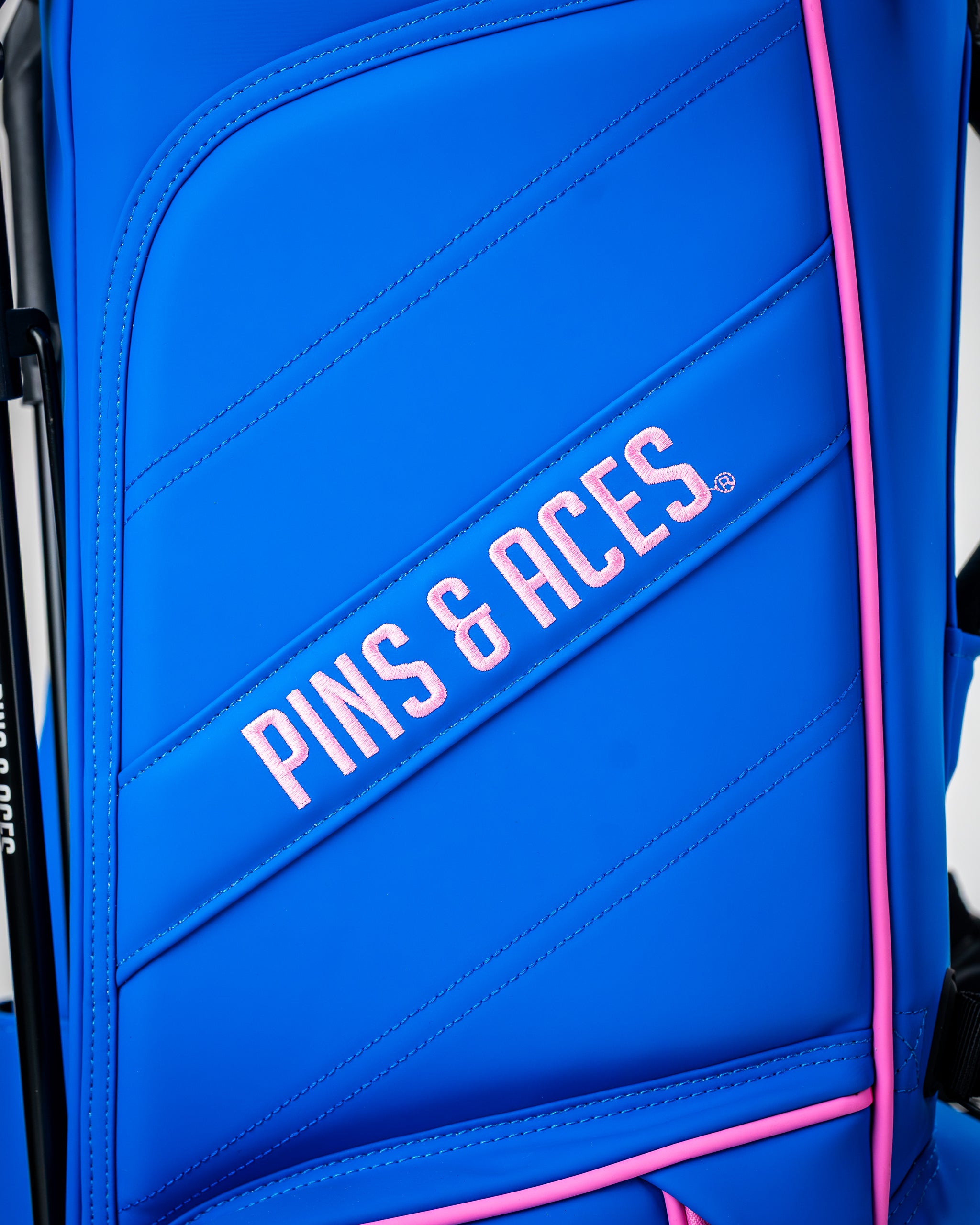 Bold blue raspberry golf bag featuring the Pins & Aces logo in pink, designed for stylish golfers.