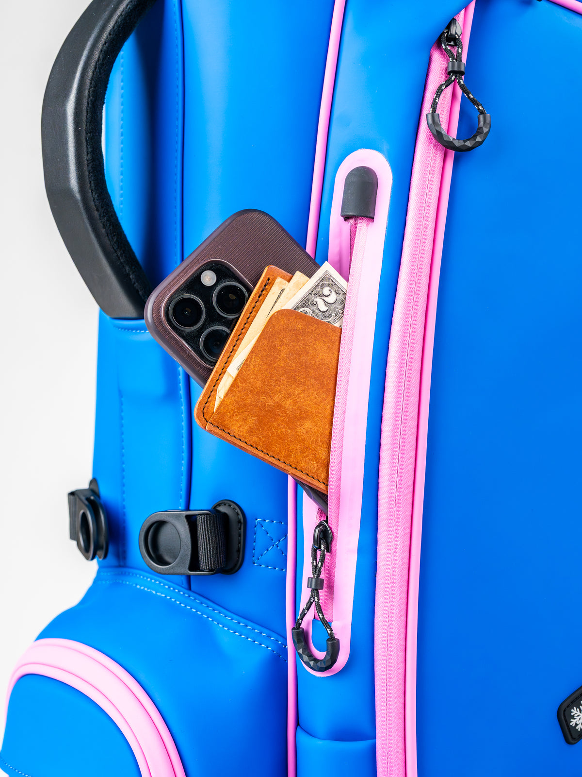 Blue Raspberry golf bag featuring a zippered pocket with a wallet and phone, showcasing its stylish and functional design.