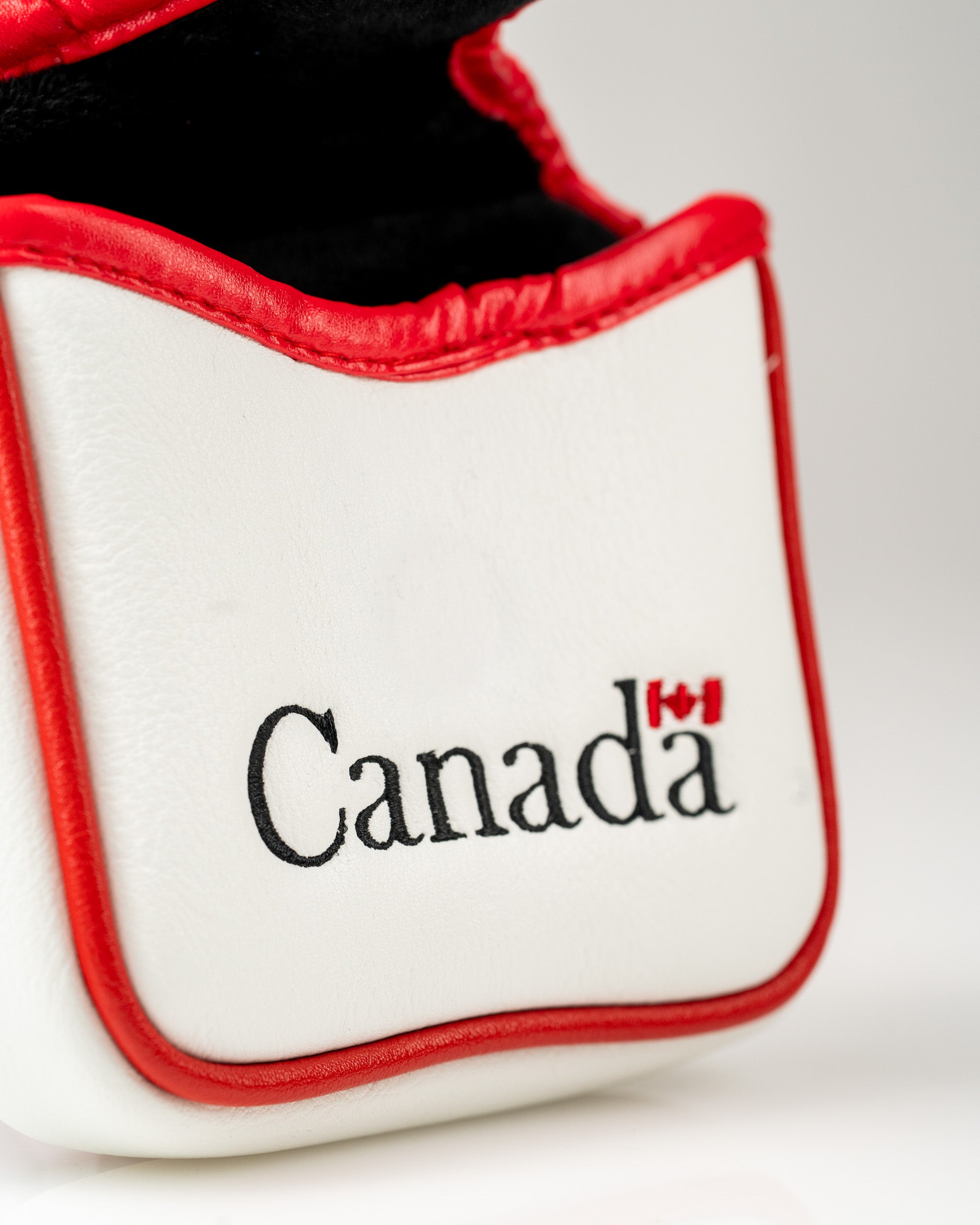 White mallet putter cover featuring "Canada" in bold black lettering with red accents, perfect for patriotic golfers.