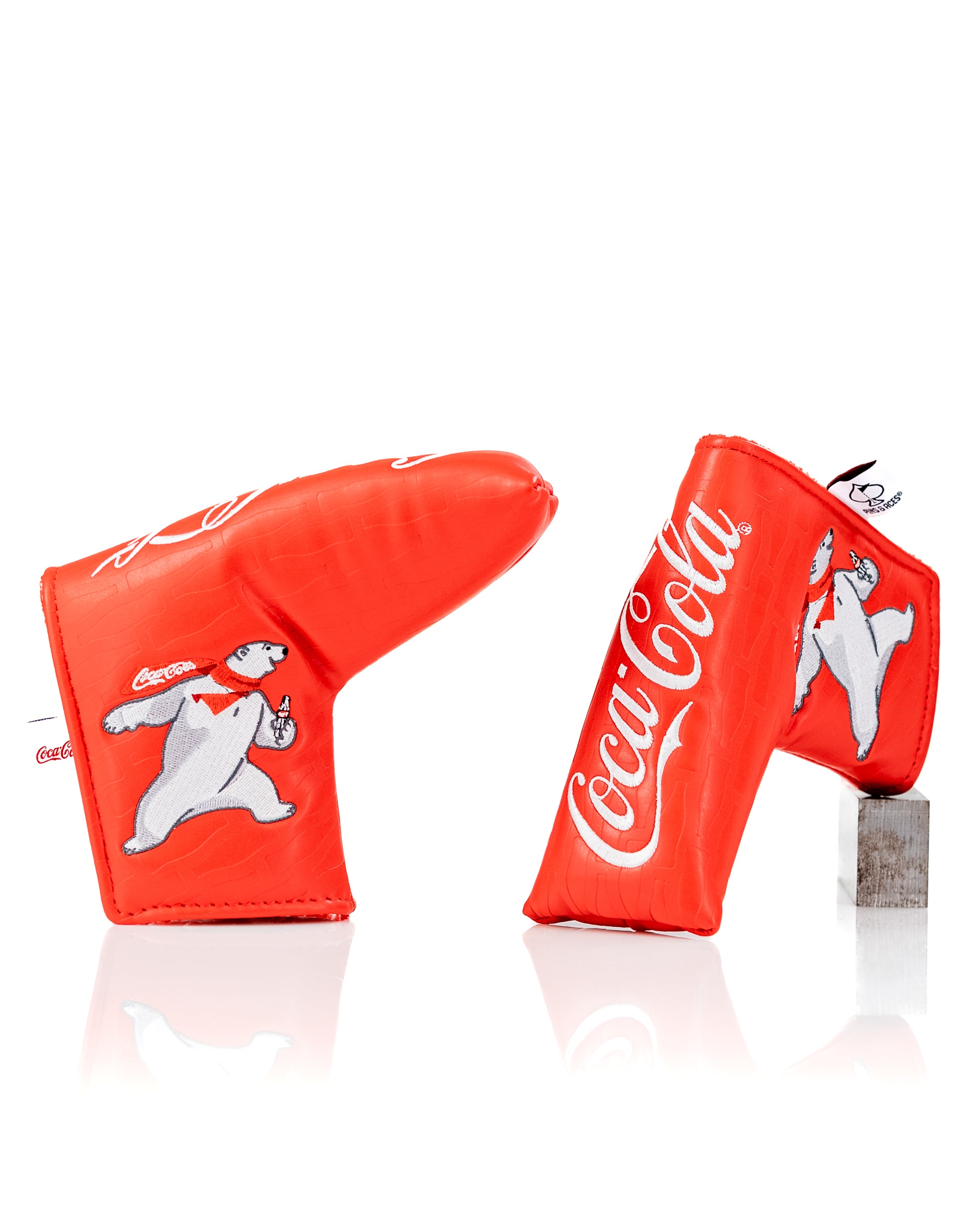 Bright red Coca-Cola blade putter cover featuring a polar bear design, perfect for golfers wanting a fun, standout accessory.
