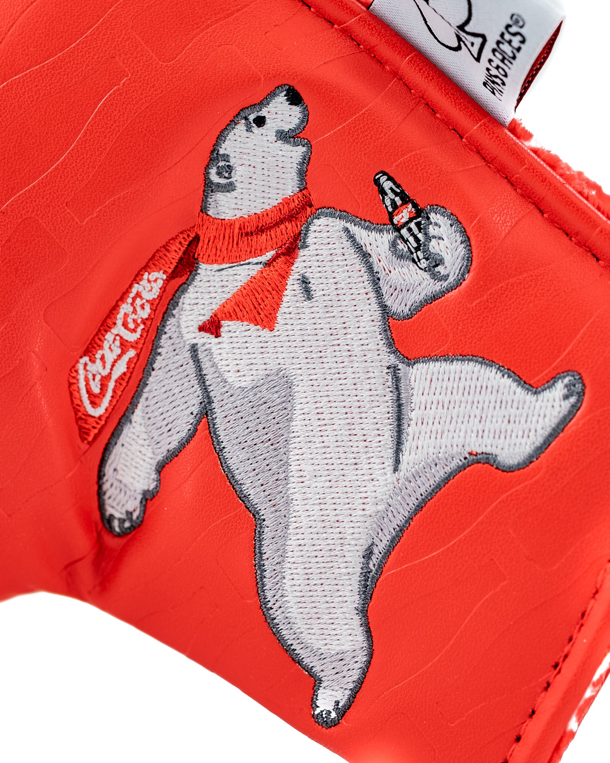 Coca-Cola Blade Putter Cover featuring a playful polar bear graphic on a vibrant red background.