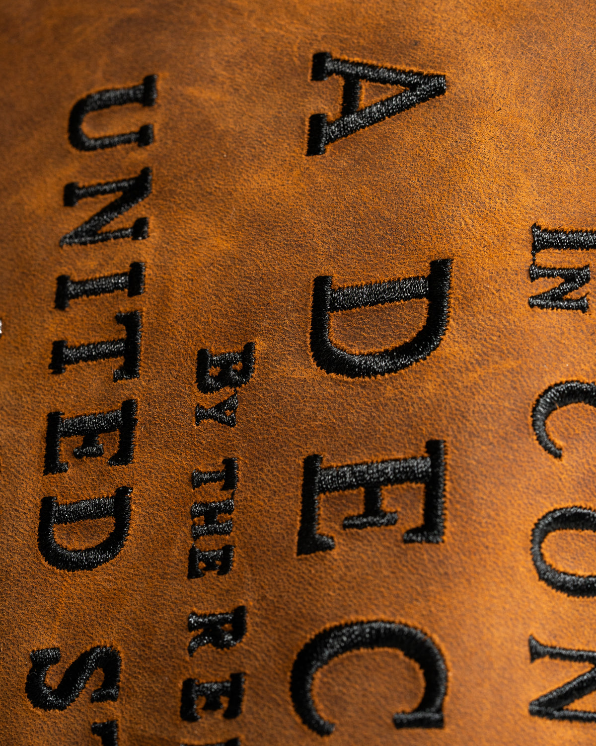 Vintage leather driver cover featuring bold embroidered text, perfect for golfers seeking a unique accessory.