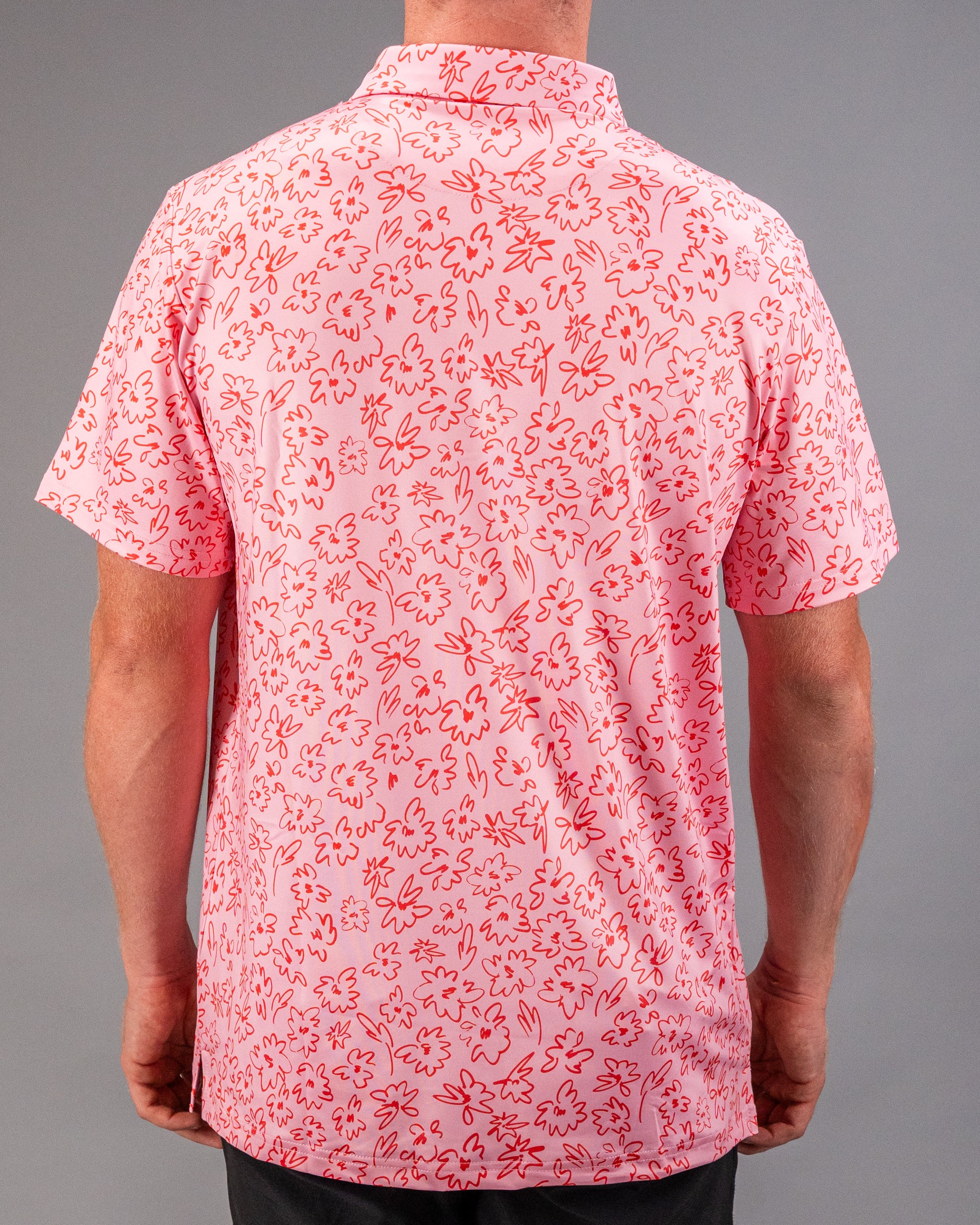 Men's short-sleeve golf shirt featuring a vibrant pink floral doodle pattern, perfect for a stylish day on the course.