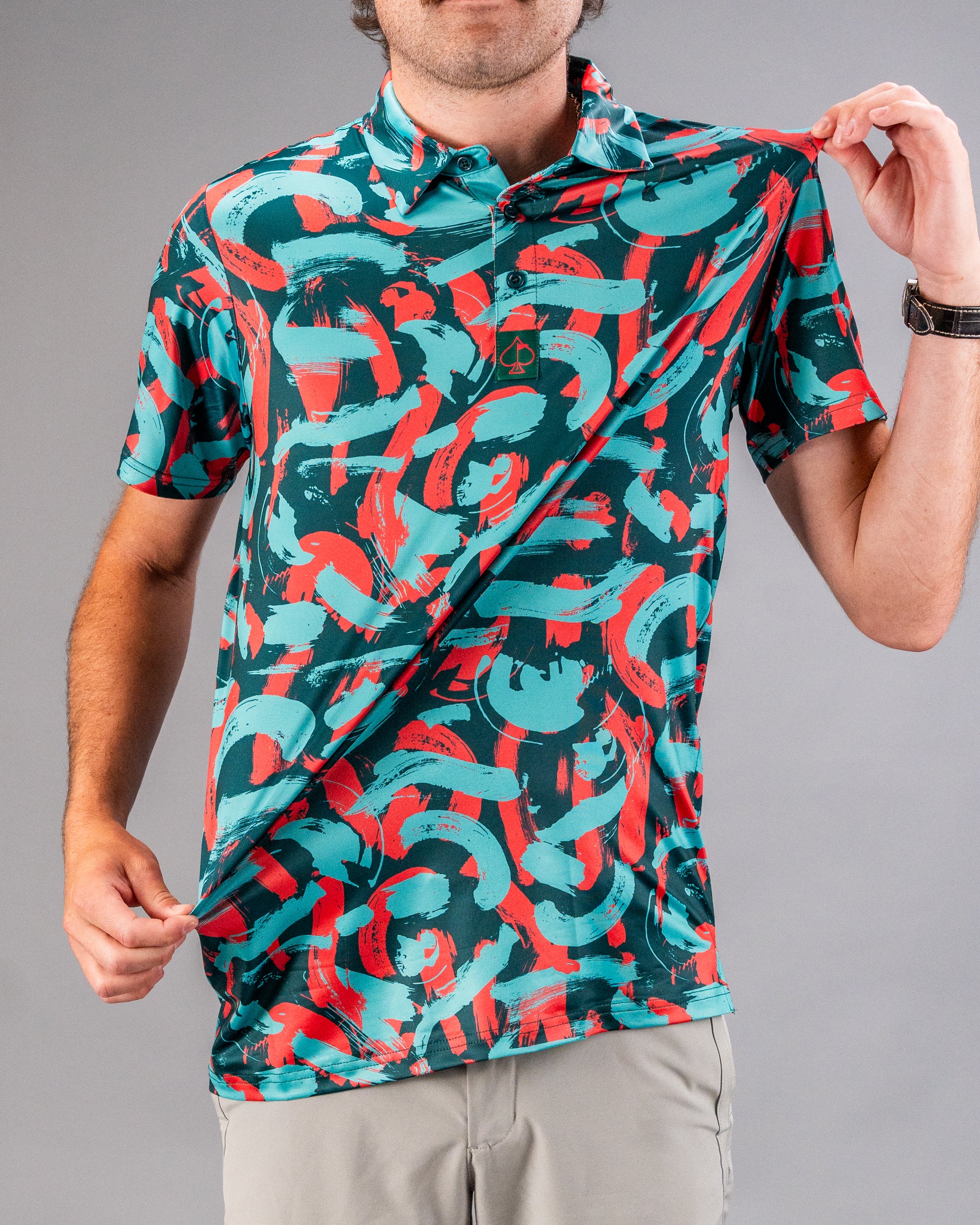 Bold golf polo featuring a vibrant coral and teal paint stroke design, perfect for golfers looking to stand out on the course.