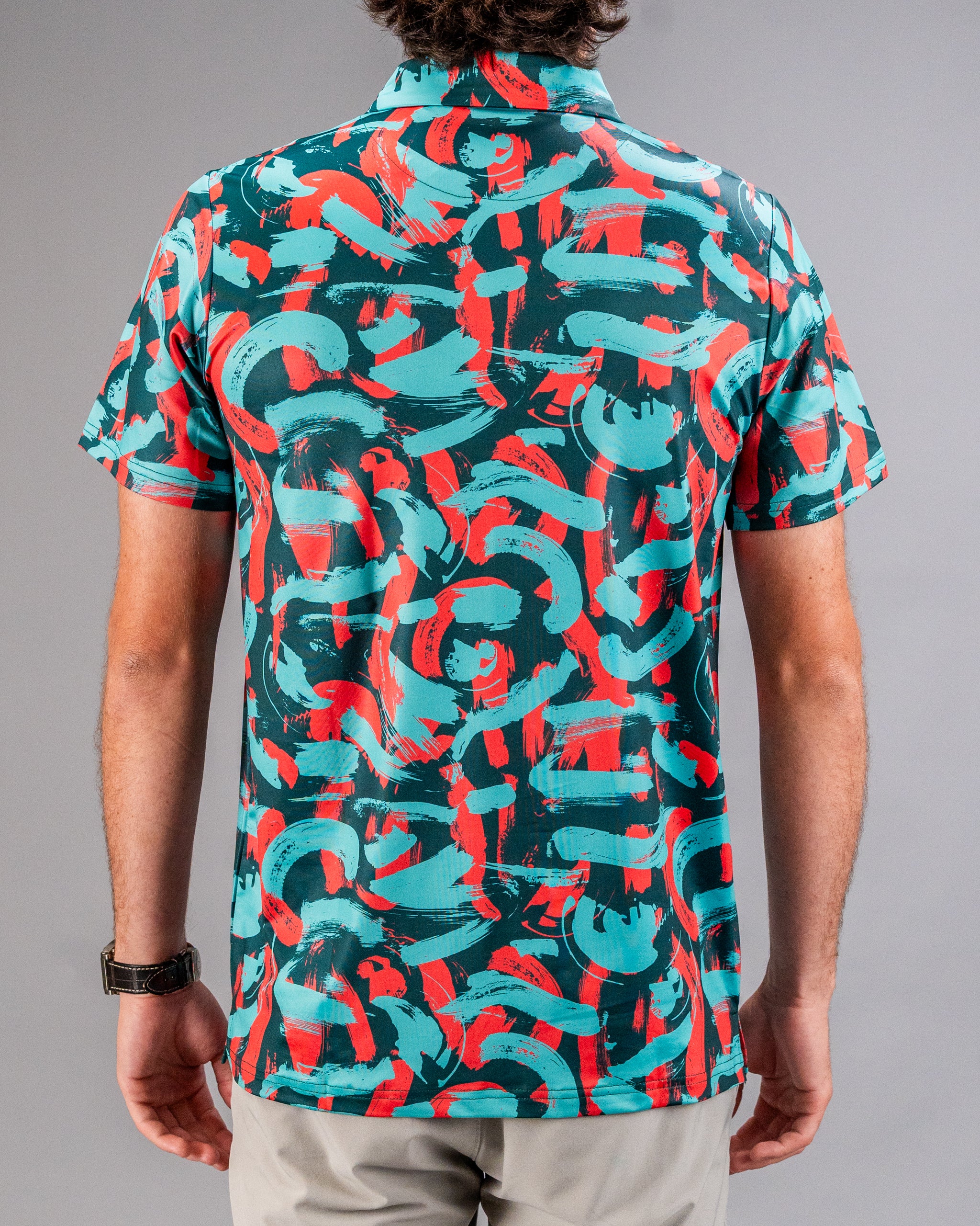 Men's short-sleeve golf shirt featuring a vibrant coral and teal paint stroke pattern, perfect for stylish on-course wear.