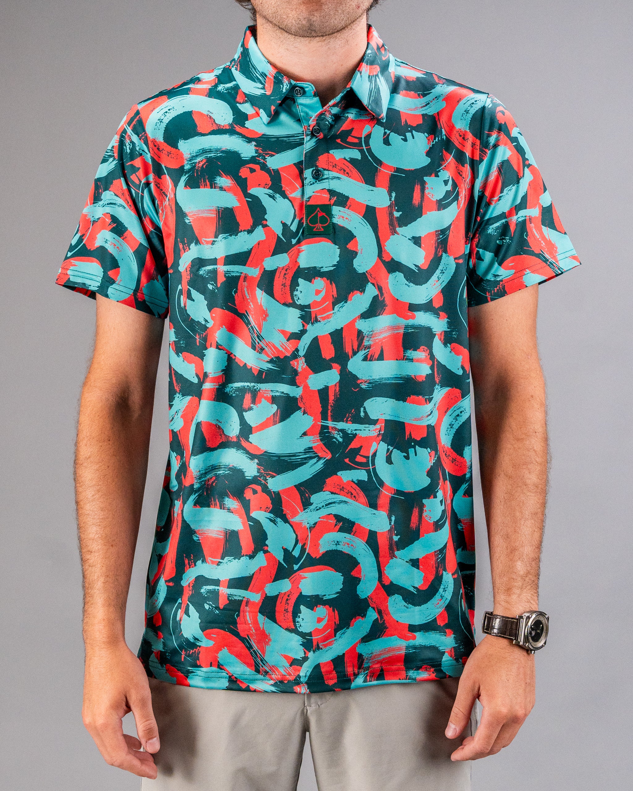 Men's golf polo featuring a vibrant coral and teal paint stroke pattern, perfect for making a bold statement on the course.