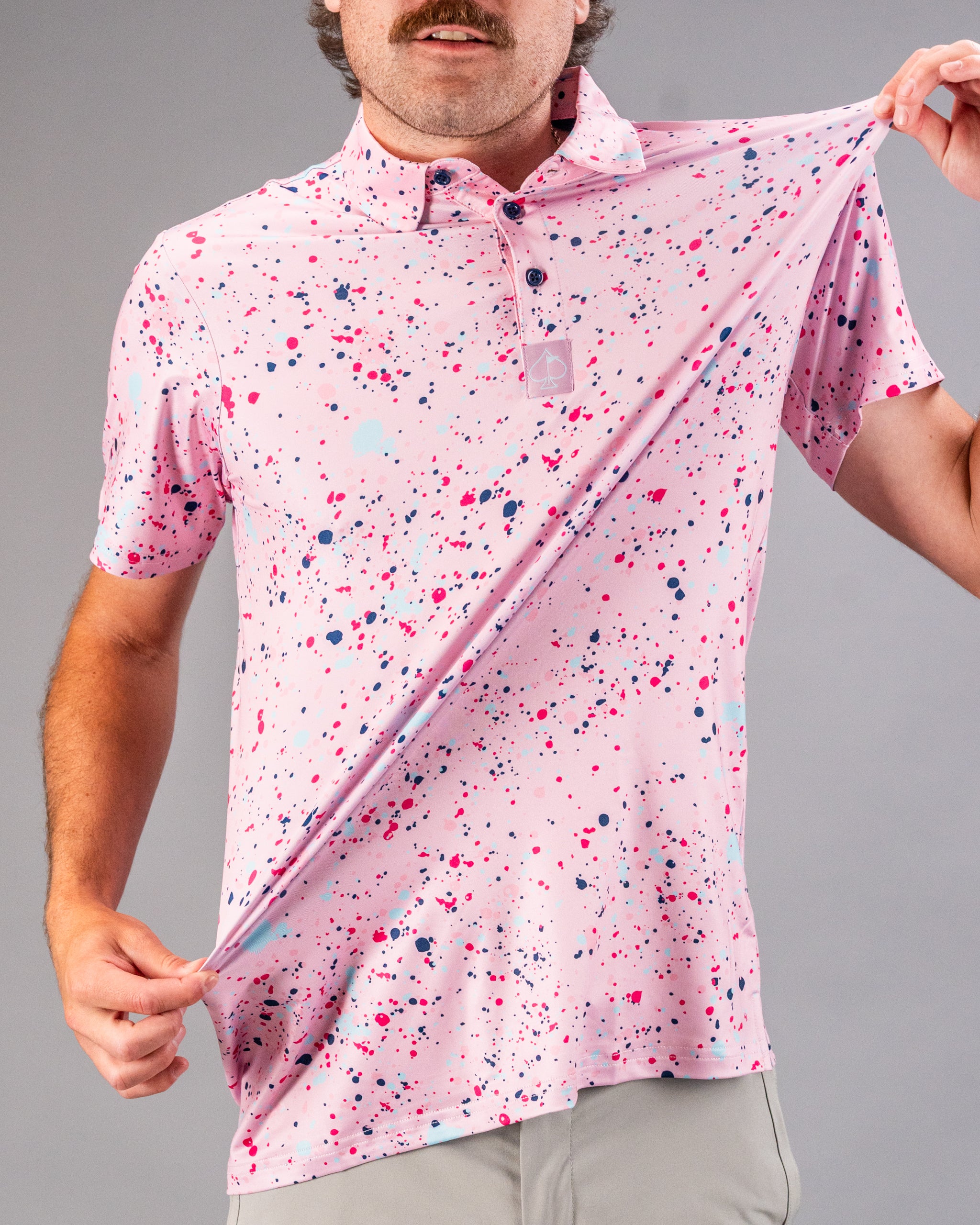 Men's pink splatter golf polo shirt featuring a vibrant design with colorful paint splashes, perfect for a bold look on the course.