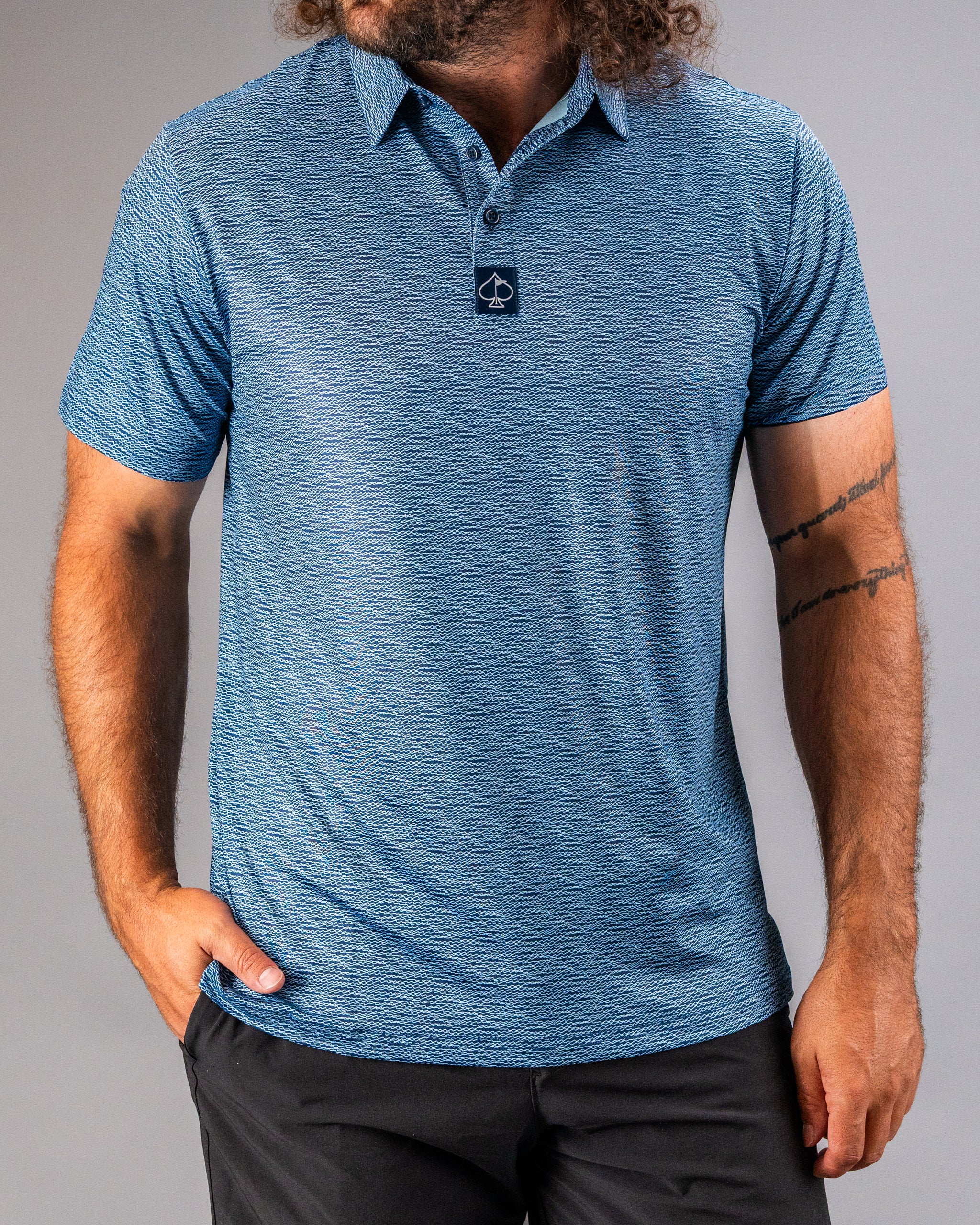 Men's blue polo shirt featuring a textured squiggle pattern, designed for stylish comfort on the golf course.