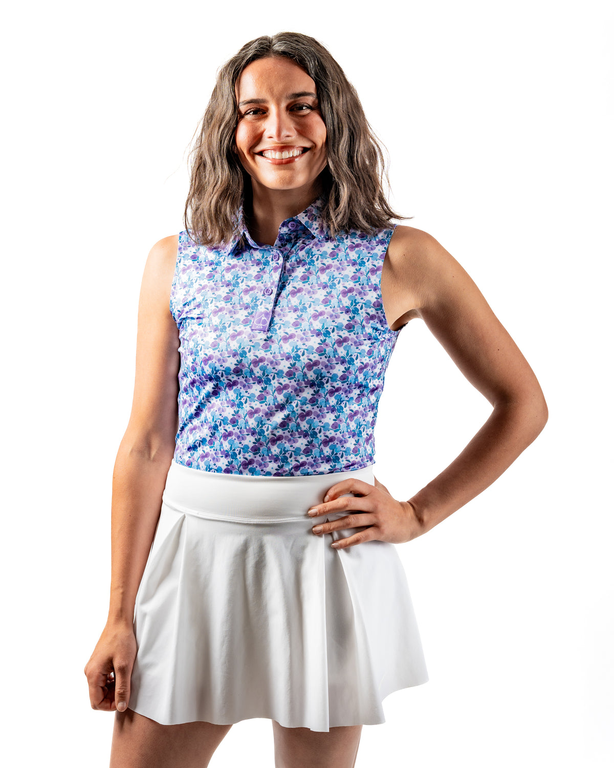 Women's white golf skirt paired with a floral sleeveless top, perfect for stylish comfort on the course.