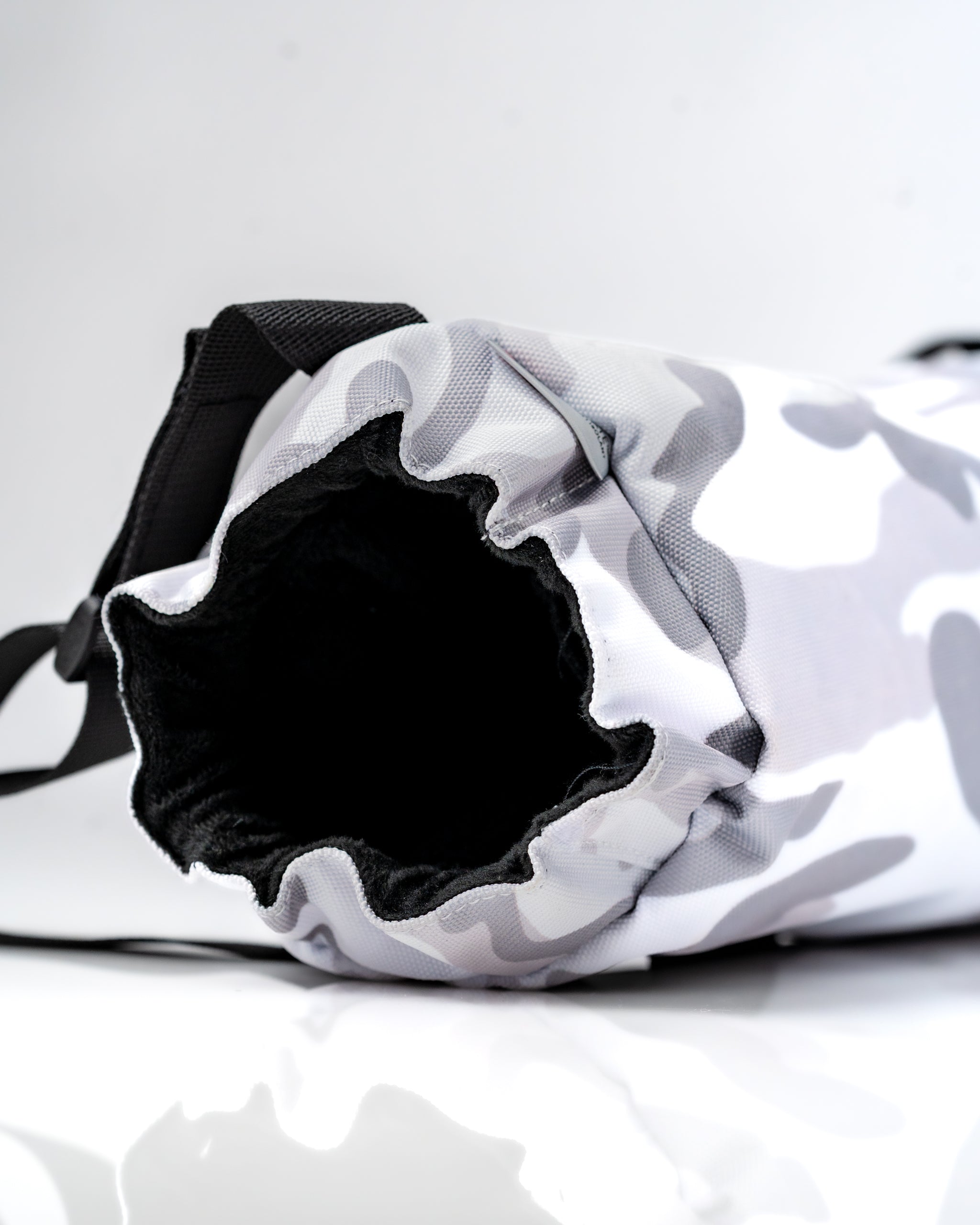 Close-up of the opening of a camo-patterned electric hand warmer with a soft interior, designed for golfers.