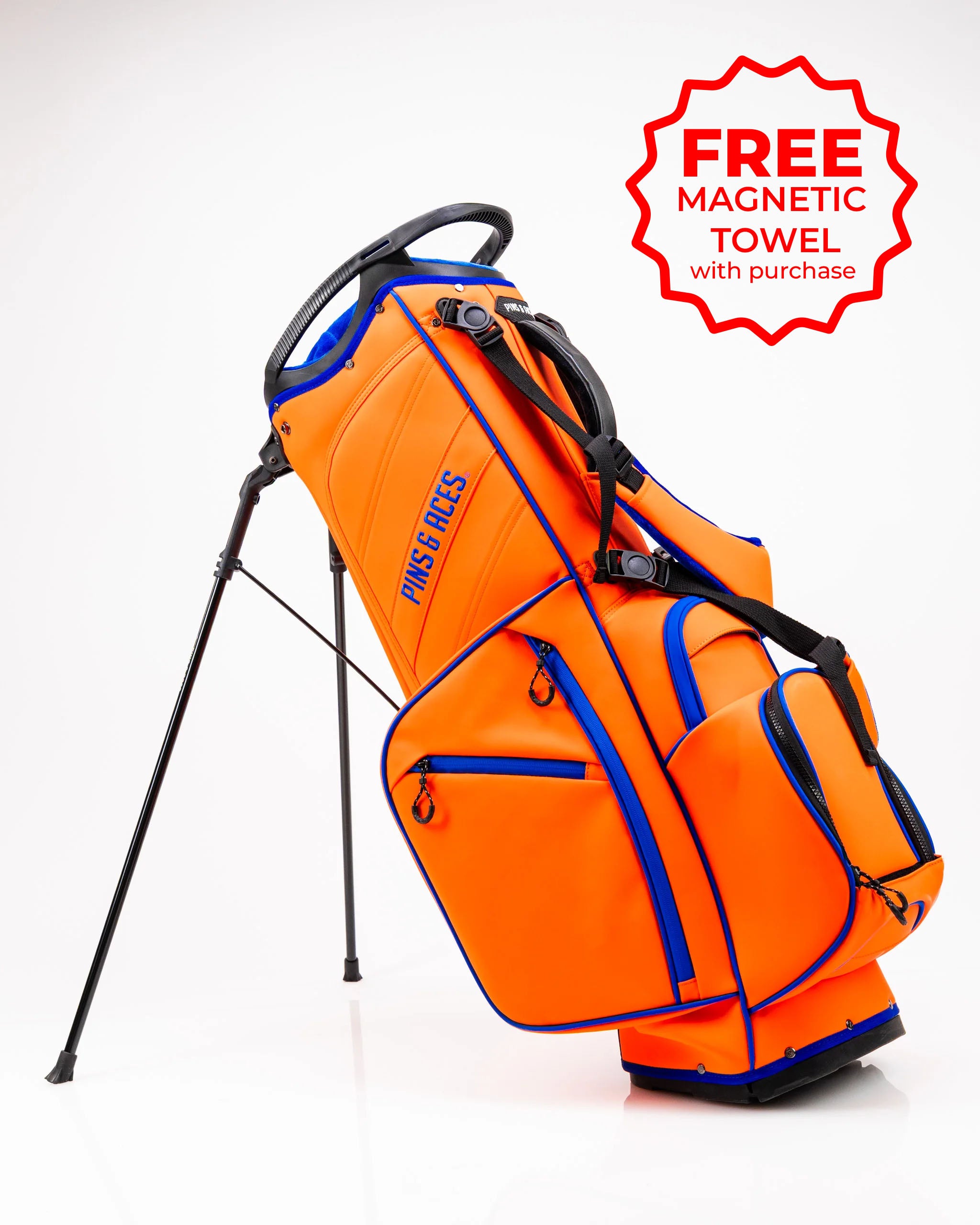 Bold orange golf bag with blue accents, featuring a stand and multiple pockets. Includes a free magnetic towel with purchase.