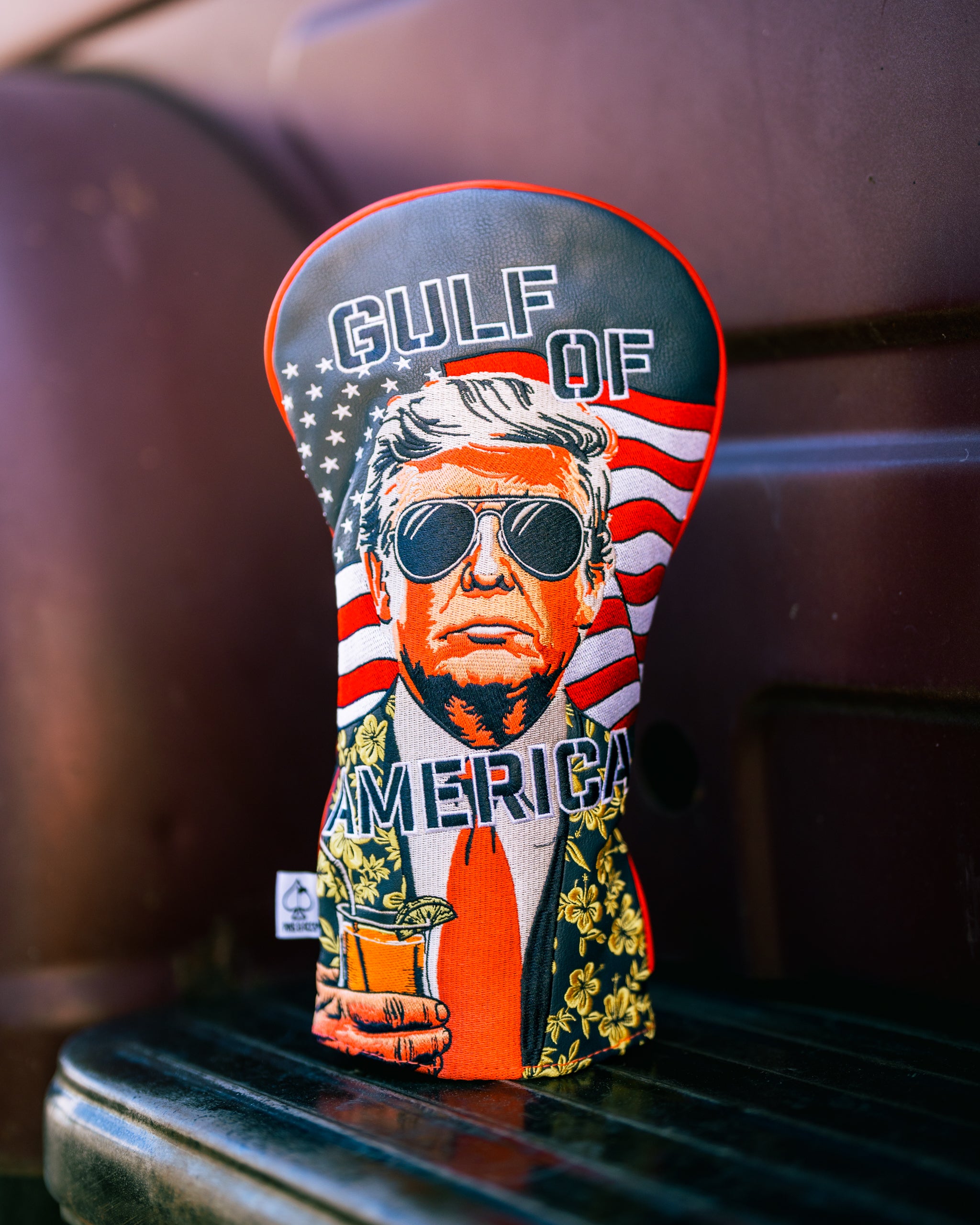 Bold driver cover featuring a stylized graphic of a man in sunglasses with an American flag background, labeled "Gulf of America.