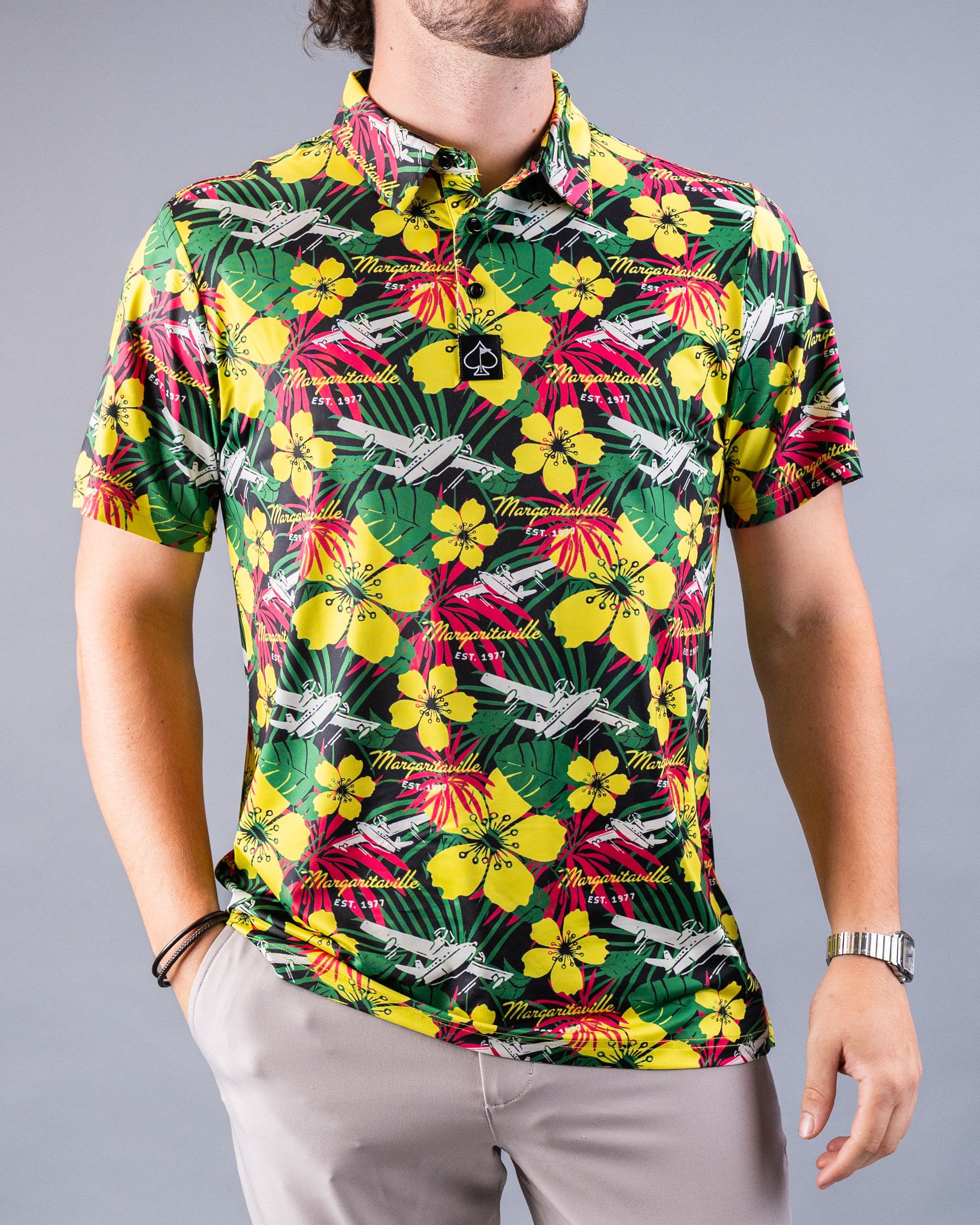 Bright tropical golf shirt with yellow hibiscus, green leaves, and white planes, featuring "Margaritaville" text for bold,...