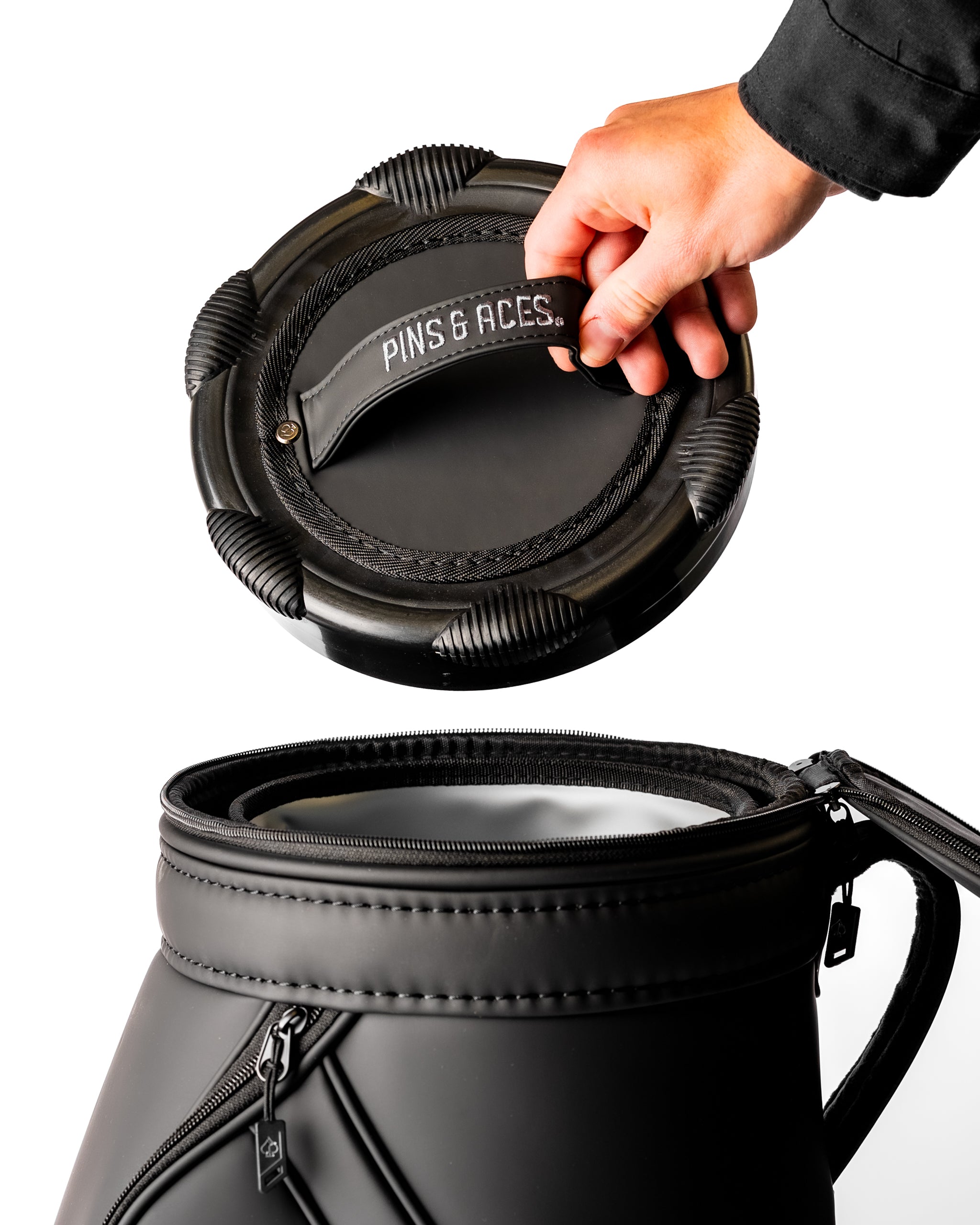 Sleek black Den Caddy with a hand lifting the lid, showcasing its stylish design and functional features for golfers.