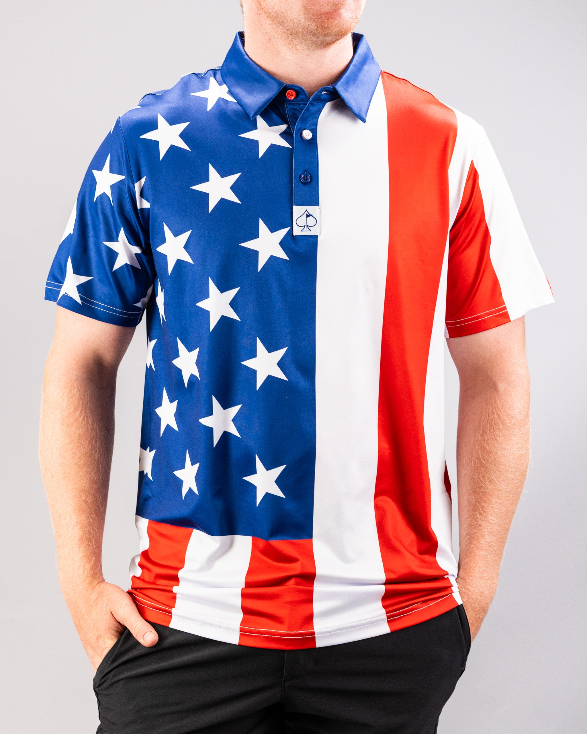 A man wearing a patriotic golf shirt featuring a design inspired by the American flag with stars and stripes in red, white, and blue.