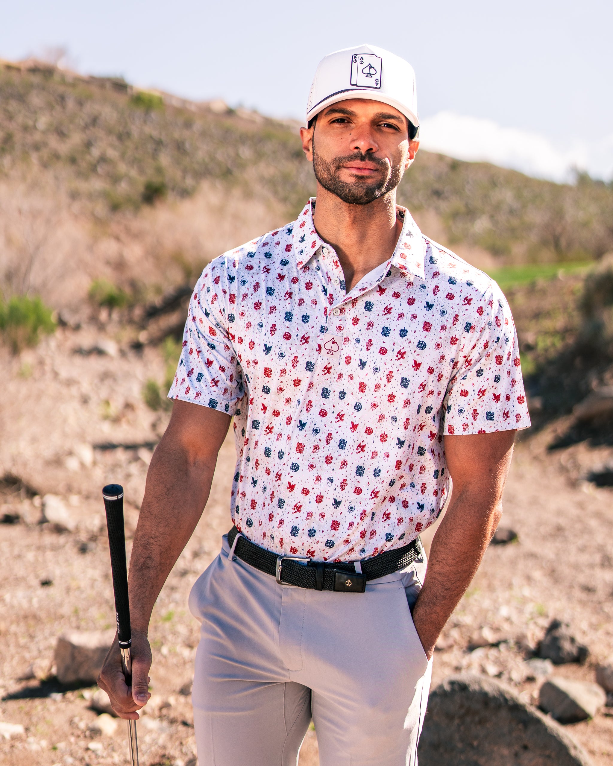 Stylish golfer in an American Traditional floral polo shirt, standing confidently on a golf course with a club.