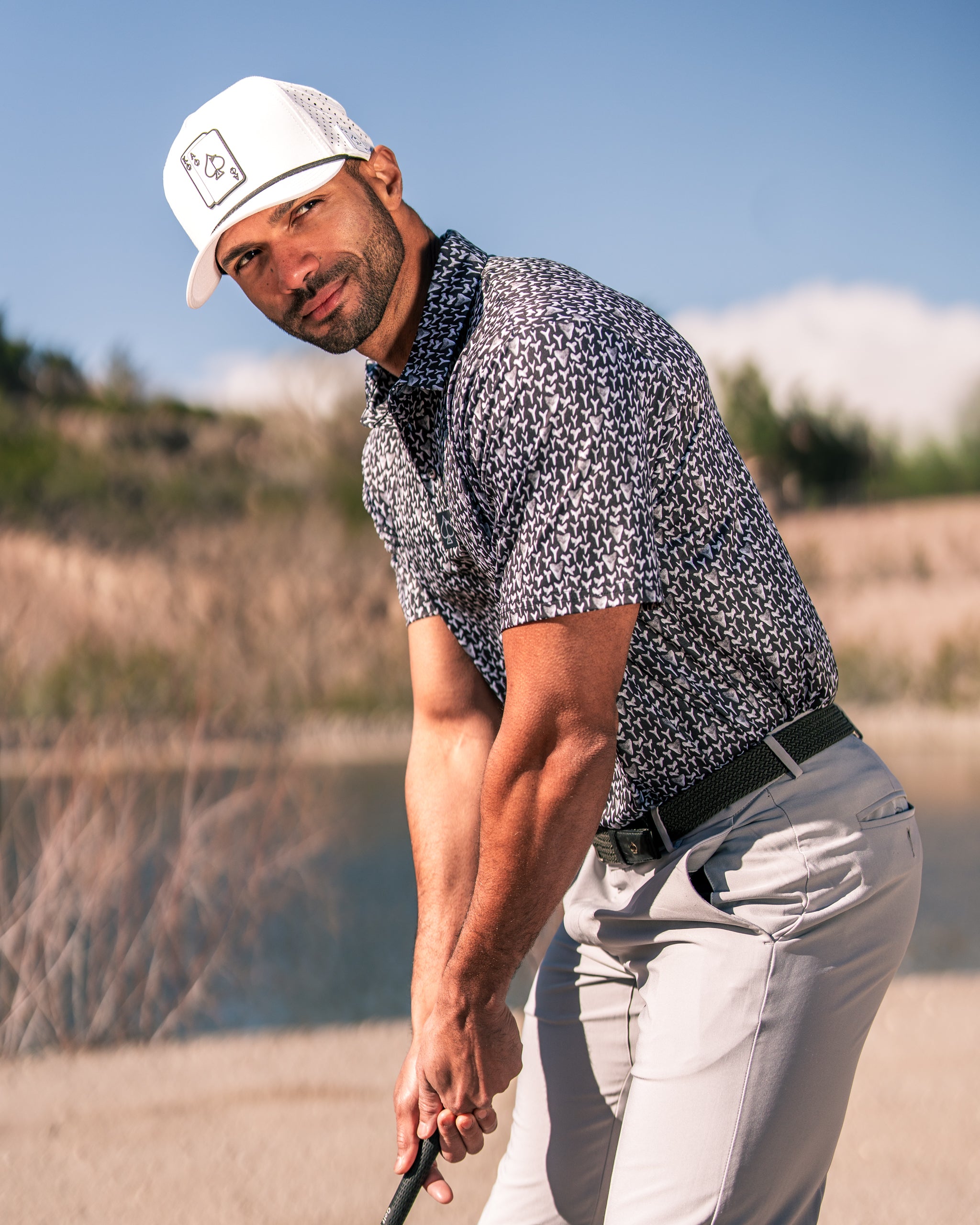 Bold golf shirt featuring a shark tooth pattern, worn by a golfer on the course, showcasing style and confidence.