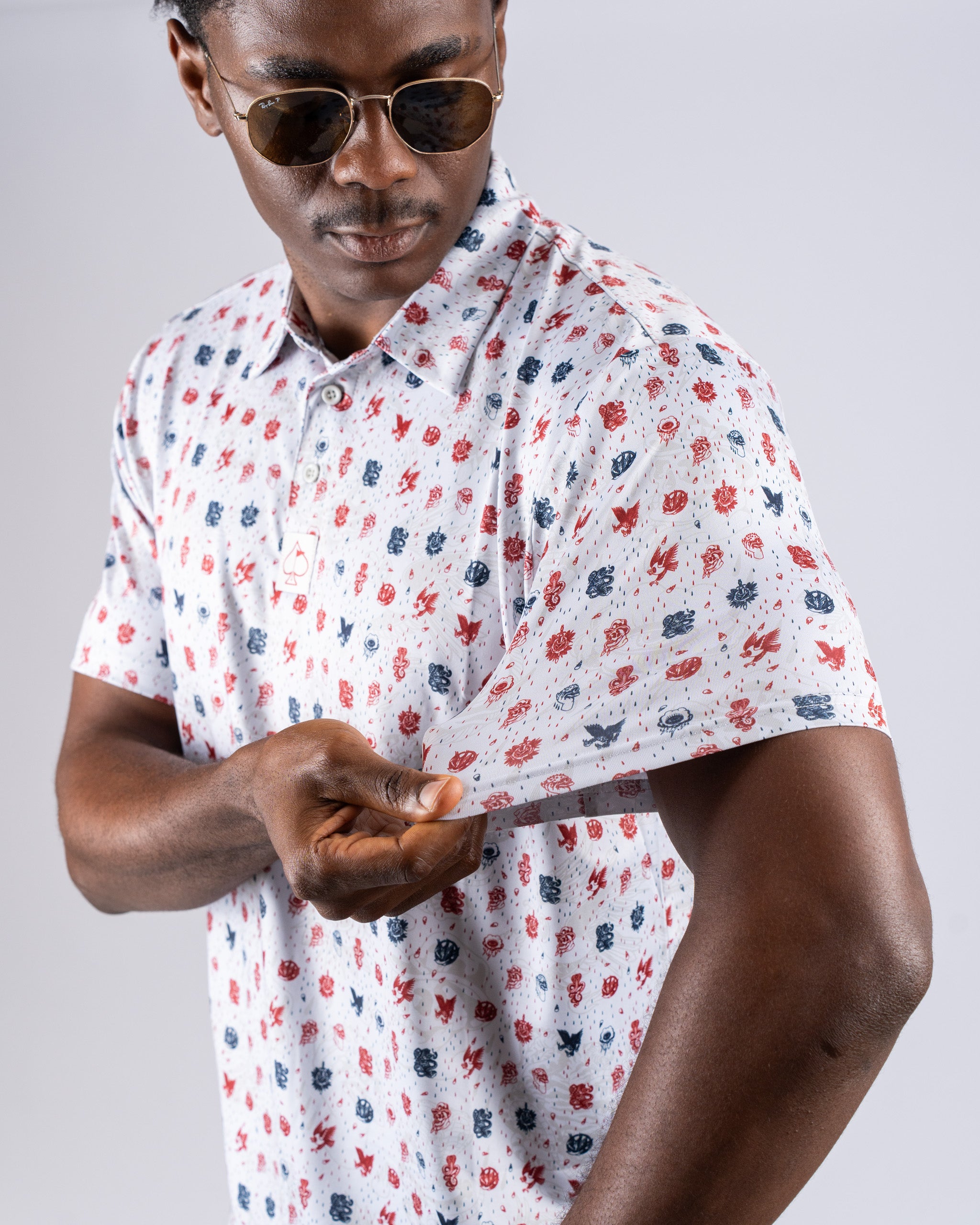 Man wearing a short-sleeve polo shirt with an American traditional pattern, showcasing its vibrant colors and design.