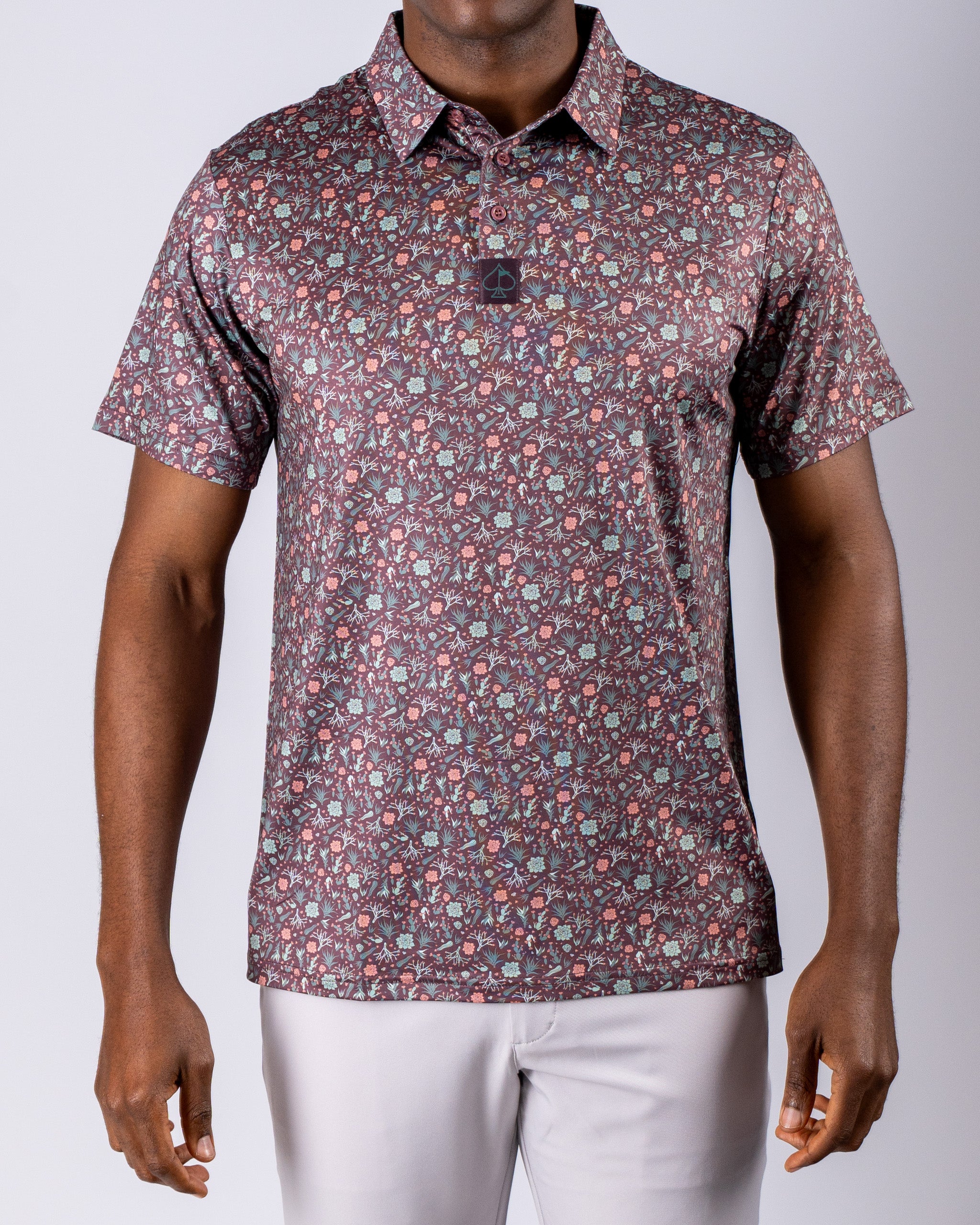 Men's Desert Sage golf polo featuring a vibrant floral pattern in shades of green, red, and purple for a bold look on the course.