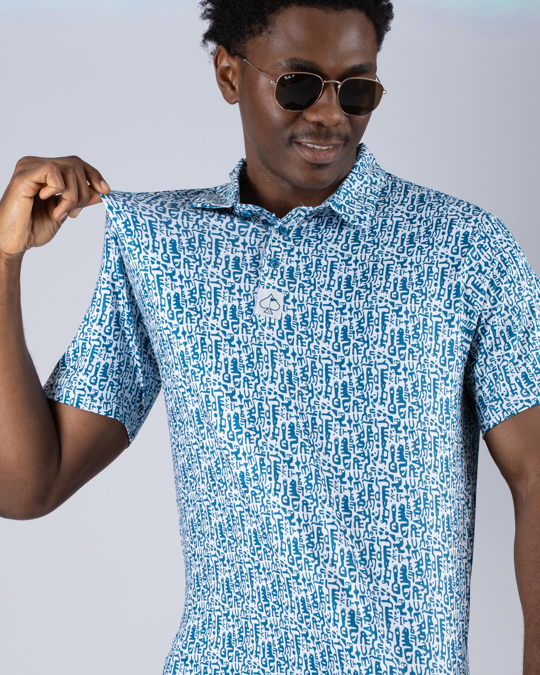 A golfer wearing a blue and white patterned polo shirt with a maze design, showcasing a stylish and bold look.