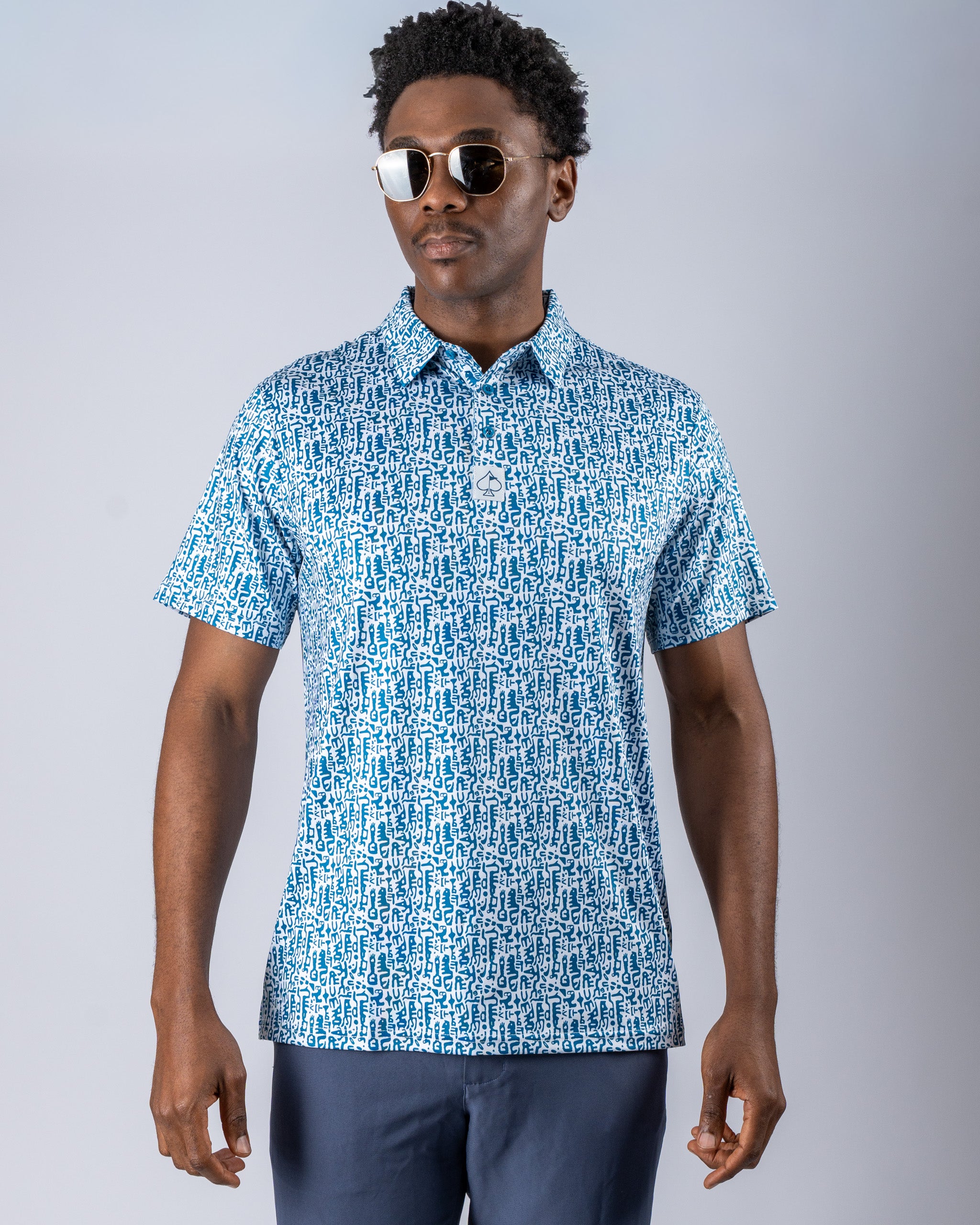 Men's short-sleeve Maze Craze golf shirt featuring a bold blue maze pattern, paired with stylish sunglasses.
