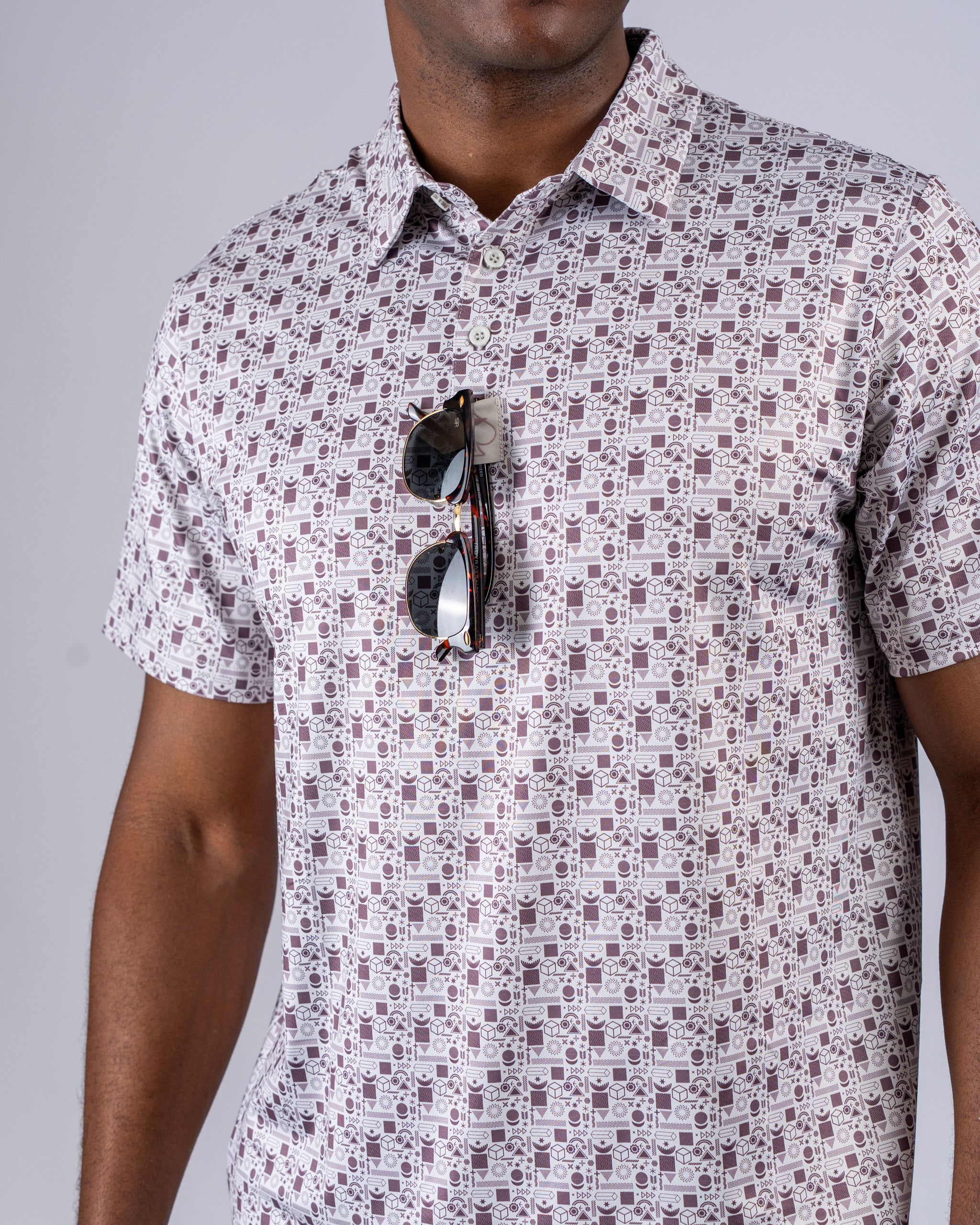 Men's retro golf shirt featuring a unique patterned design, paired with stylish sunglasses for a bold look on the course.