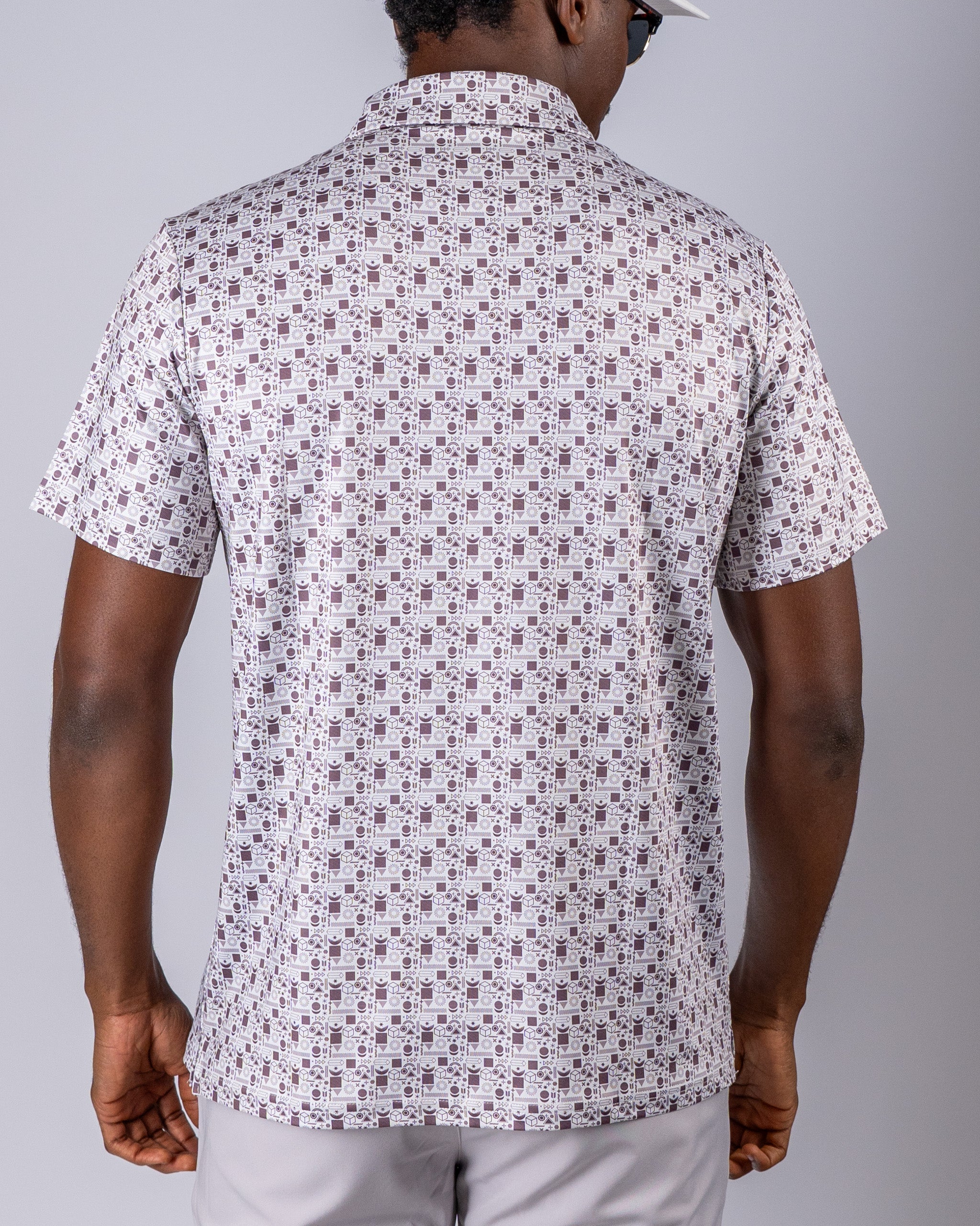 Men's short-sleeve golf shirt featuring a retro geometric pattern in muted colors, designed for a stylish look on the course.