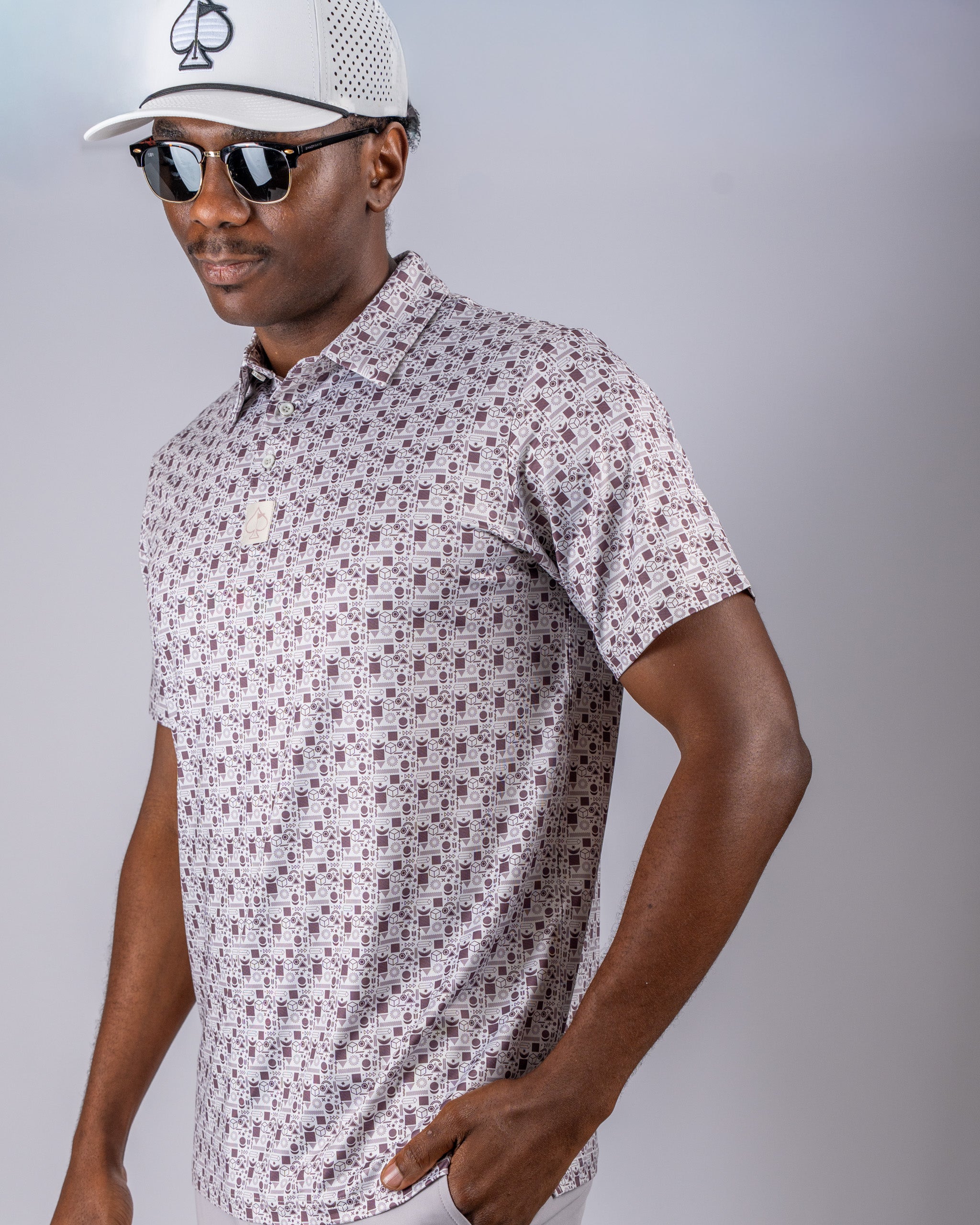 Stylish golfer wearing a patterned polo shirt and sunglasses, showcasing the Retro Form golf apparel.