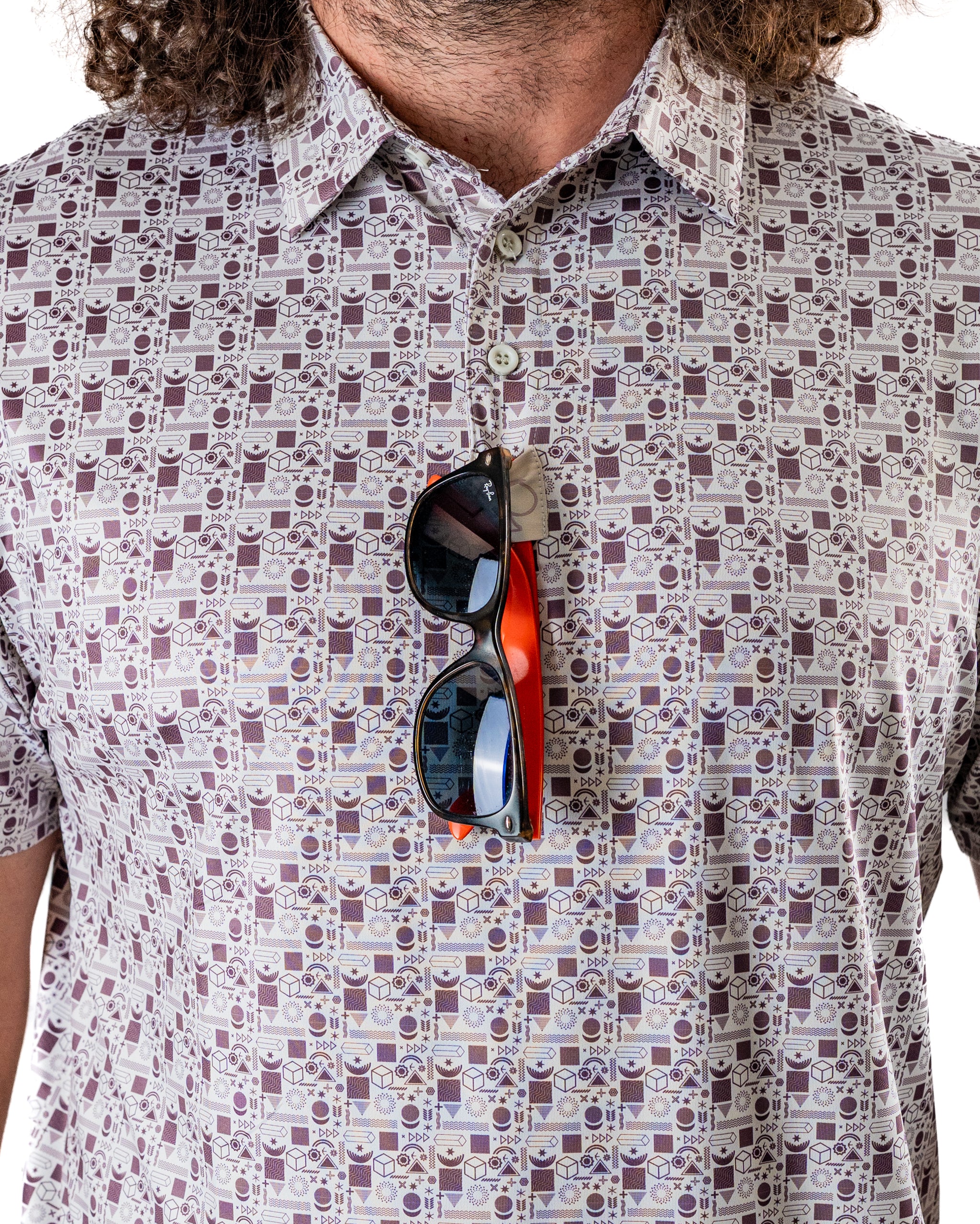 Men's retro golf shirt featuring a unique patterned design, paired with stylish sunglasses hanging from the collar.