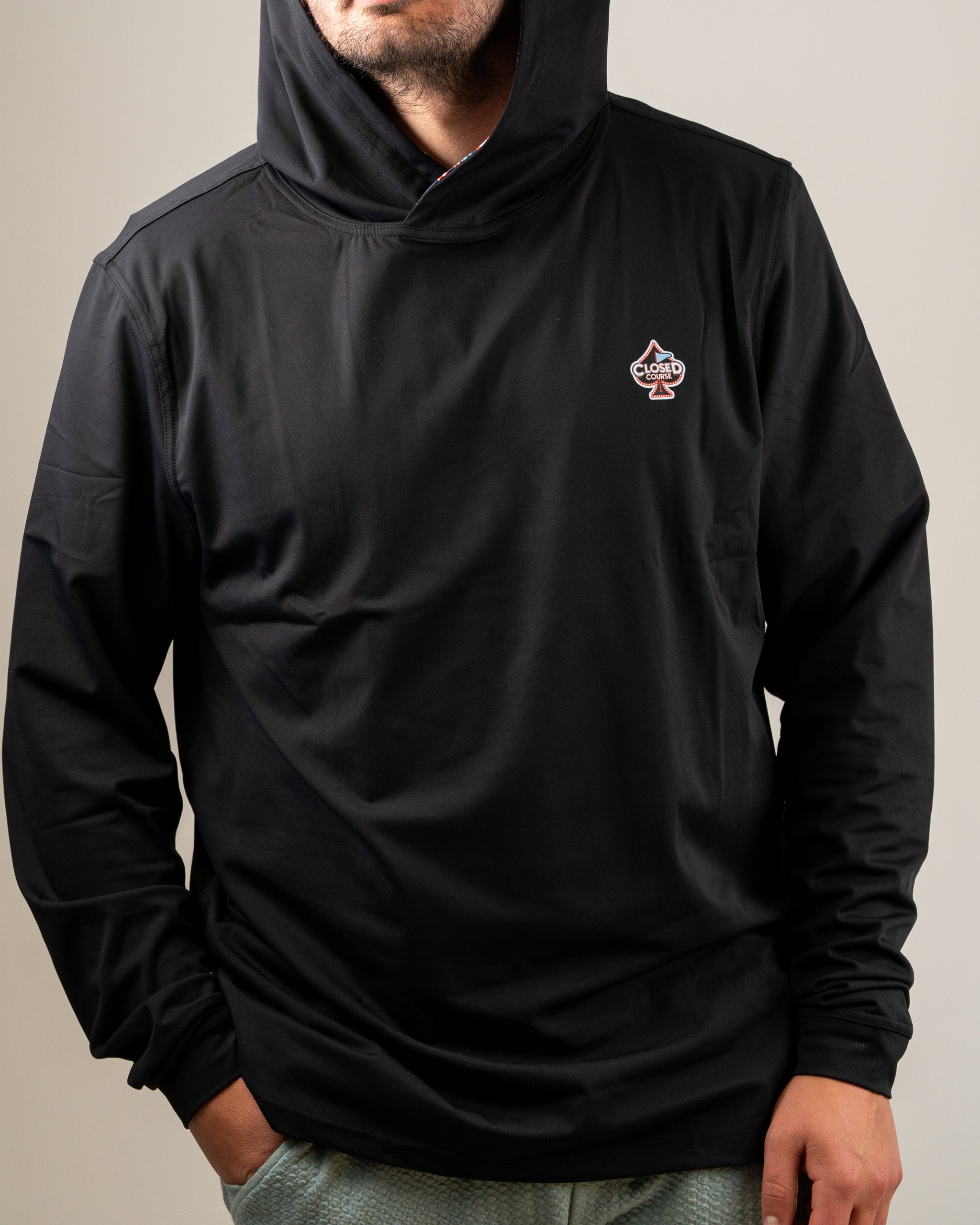 Men's black performance golf hoodie featuring a closed course logo, designed for comfort and style on the golf course.