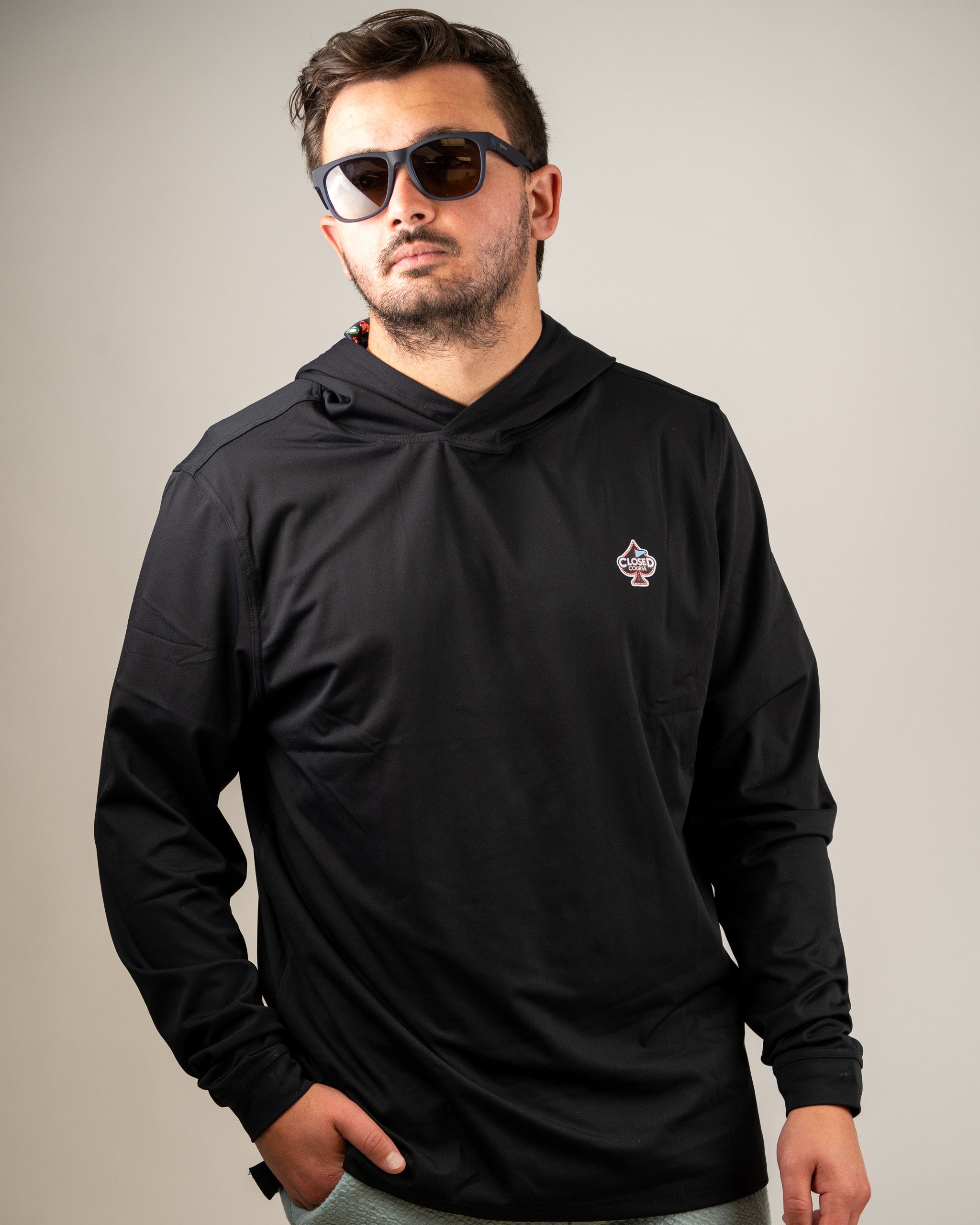 Men's black performance golf hoodie featuring a logo, designed for comfort and style on the golf course.