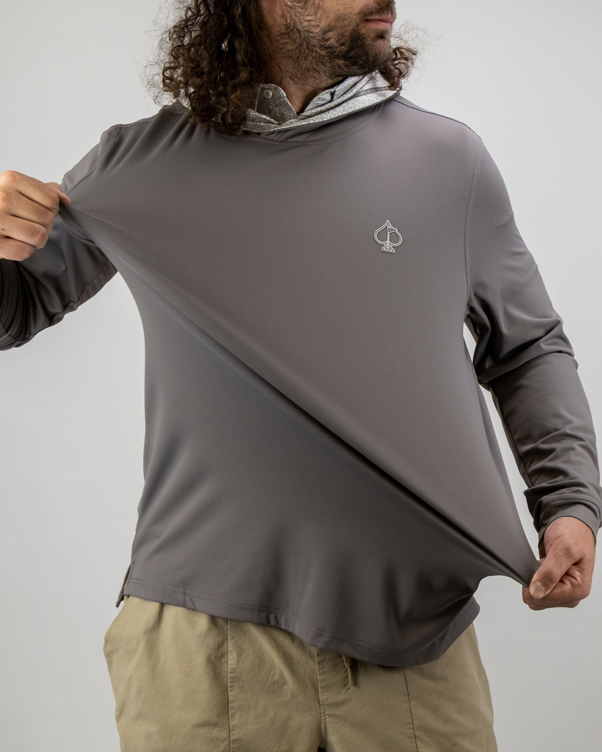 Man wearing a Performance Golf Hoodie in gray, showcasing its stretchable fabric and spade logo on the chest.