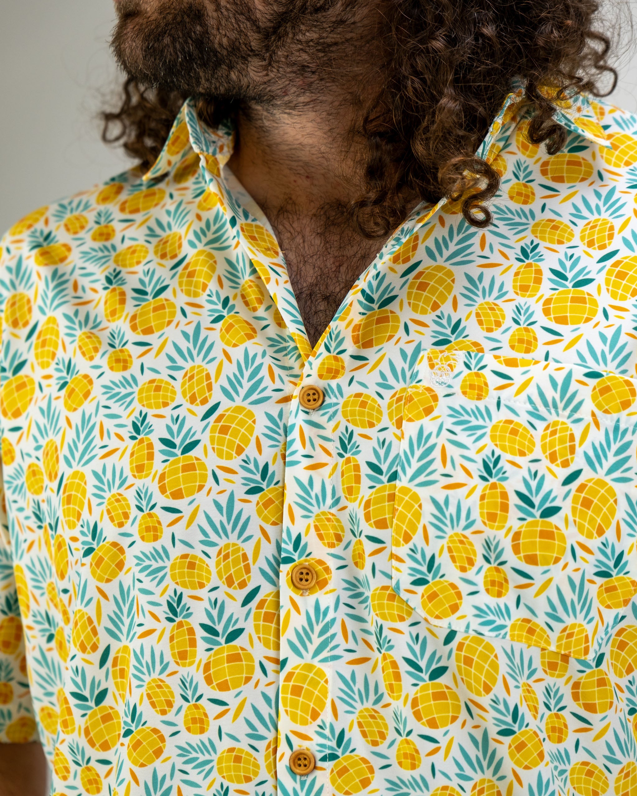 Colorful short-sleeve shirt featuring a vibrant pineapple and leaf pattern, perfect for a bold golf style.