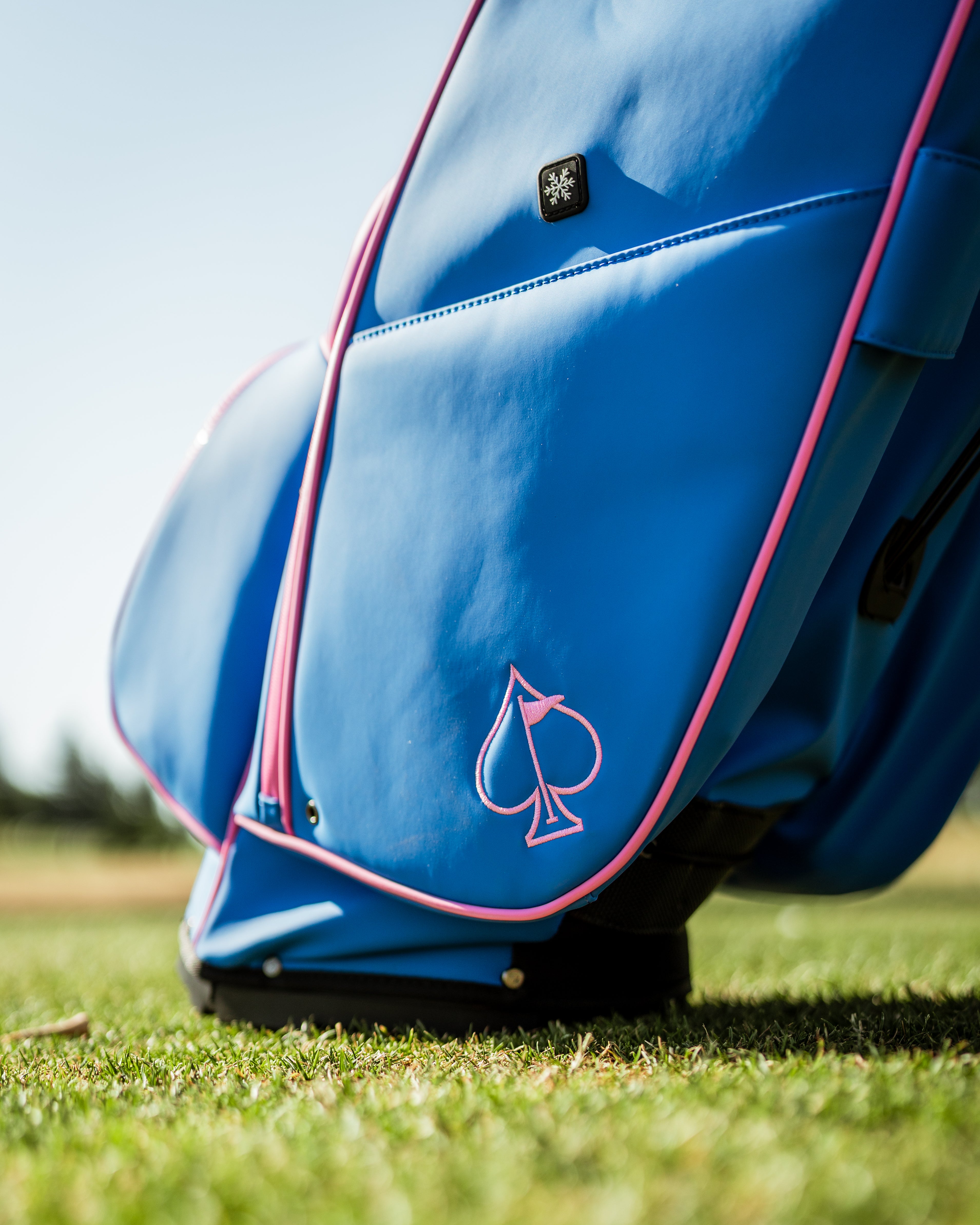 Bold blue raspberry golf bag featuring a sleek design and pink accents, perfect for stylish golfers on the course.