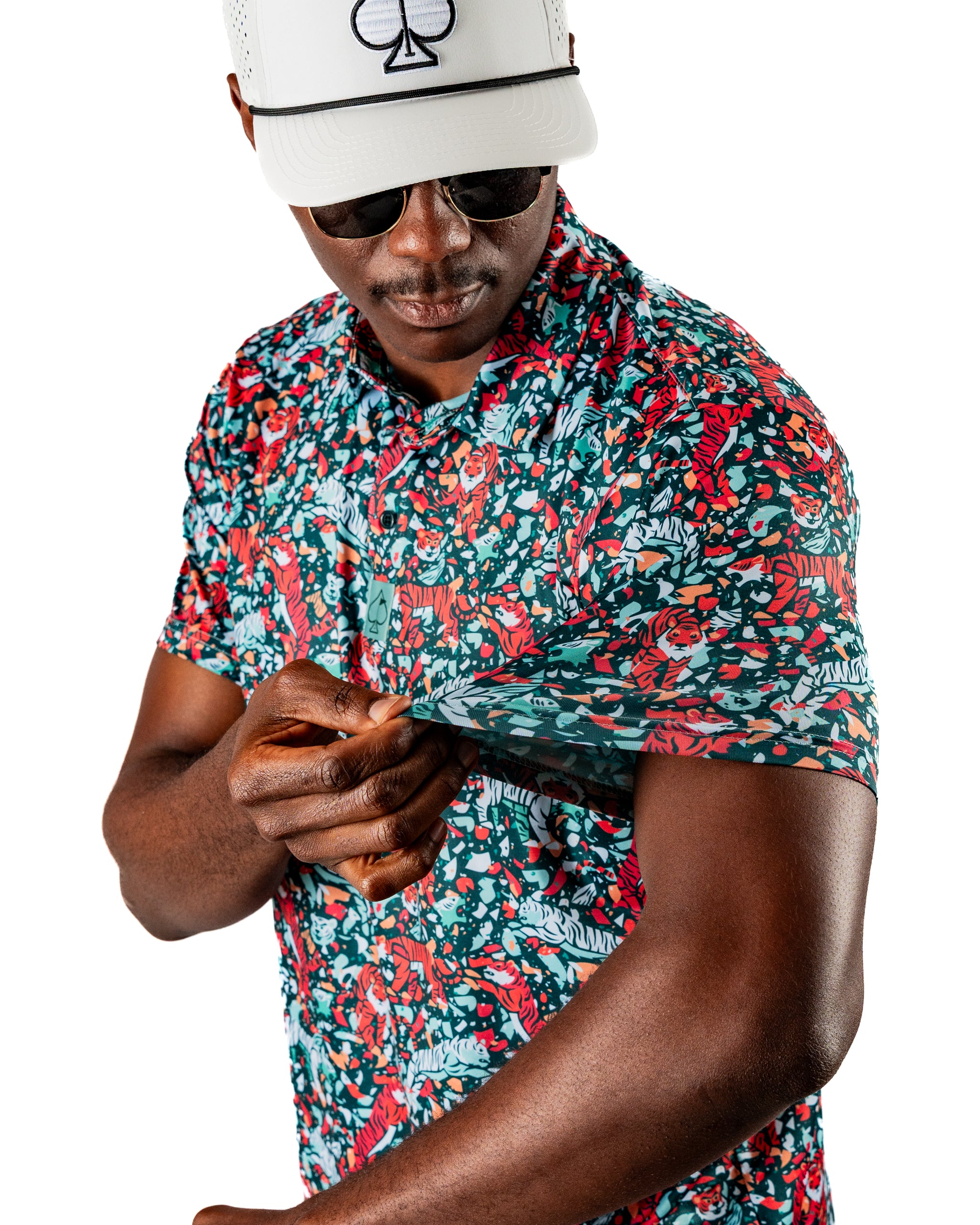 Bold Tiger Shatter Teal golf shirt featuring vibrant floral and tiger patterns, worn by a man adjusting the sleeve.