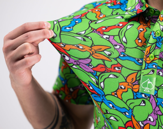 Colorful golf shirt featuring a vibrant pattern of Teenage Mutant Ninja Turtles, showcasing bold graphics and playful design.