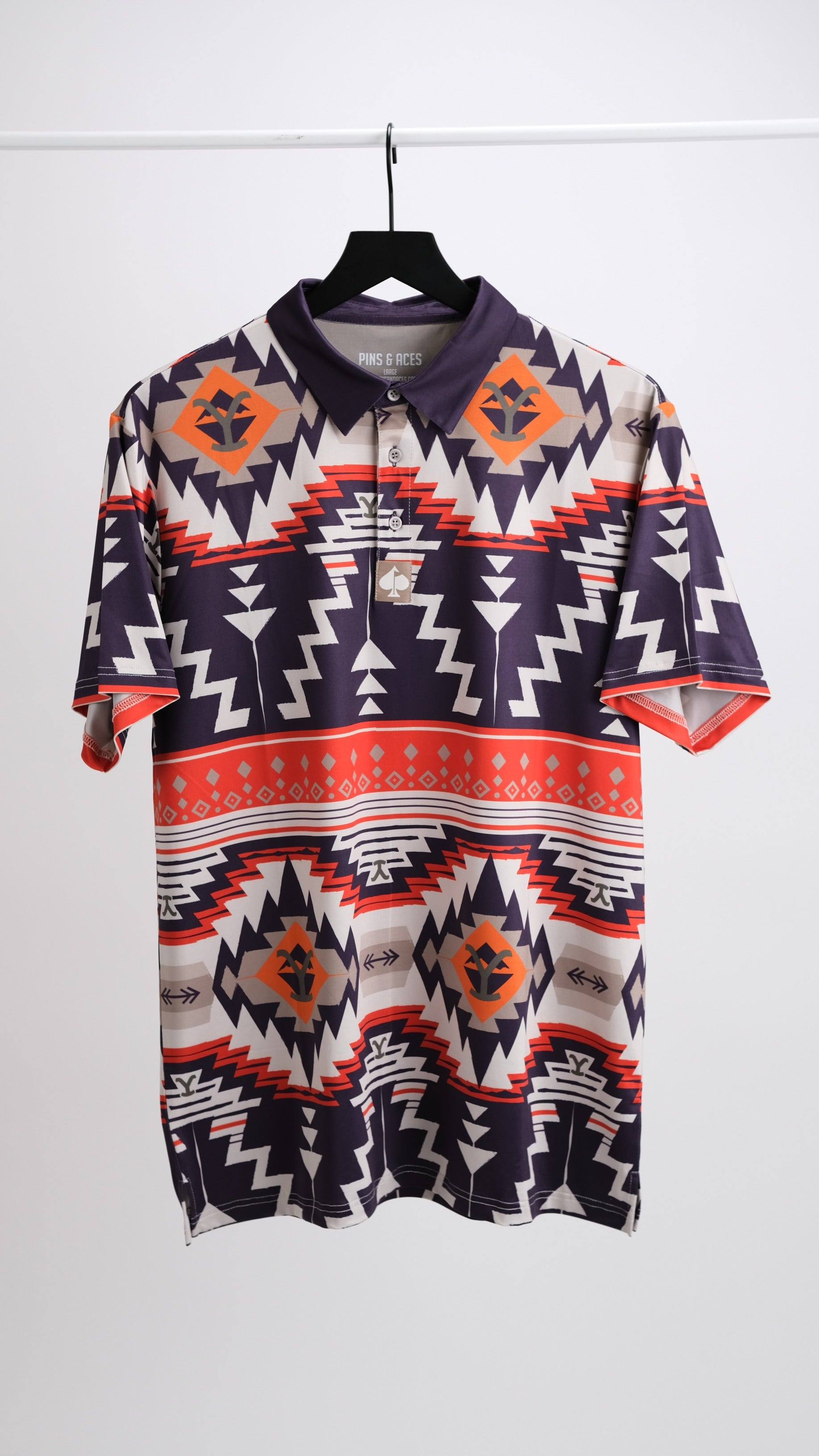 Bold patterned polo shirt featuring a vibrant rustic ranch design with geometric shapes in earthy tones. Perfect for golfers.