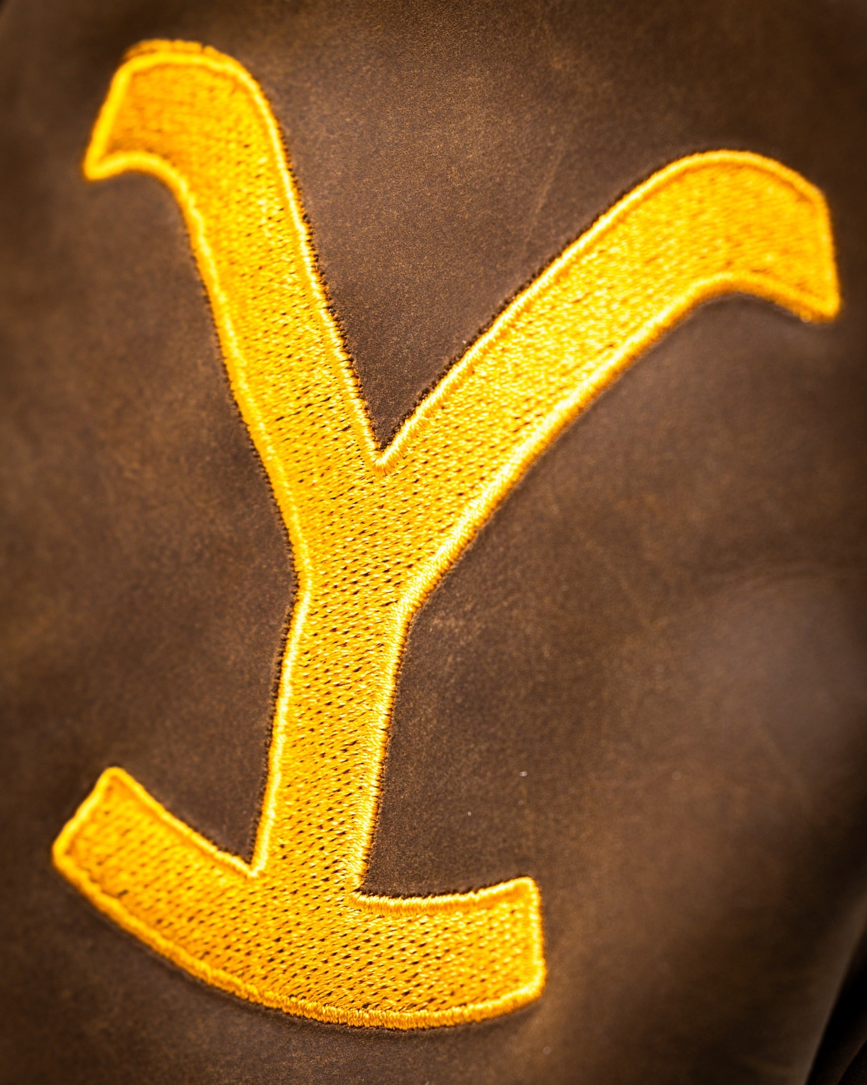 Yellowstone Driver Cover featuring a bold yellow embroidered 'Y' on a rich brown leather background.