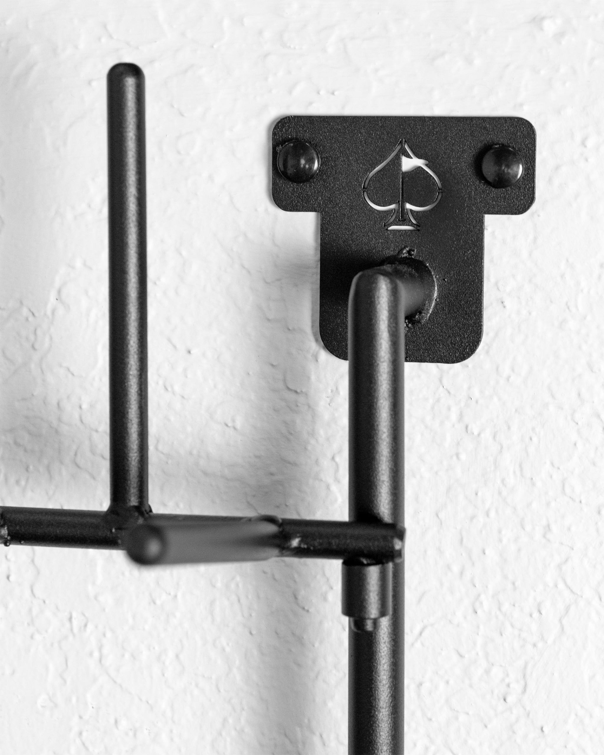 Stylish black headcover rack designed for organizing golf headcovers, featuring a sleek spade logo. Perfect for golfers.