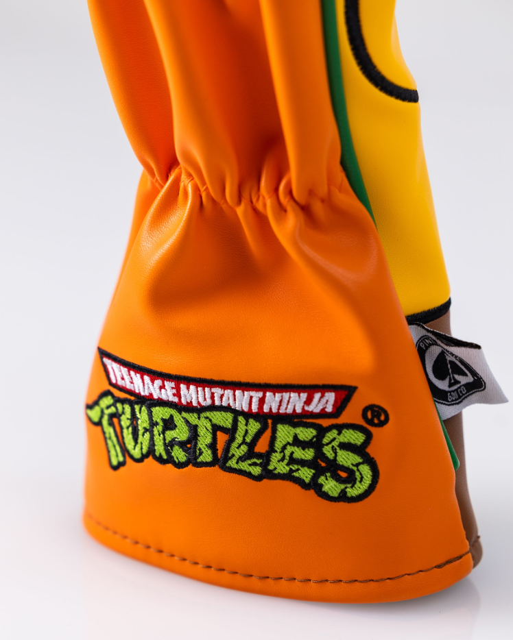 Michelangelo fairway cover featuring vibrant orange design and Teenage Mutant Ninja Turtles logo for bold golf style.