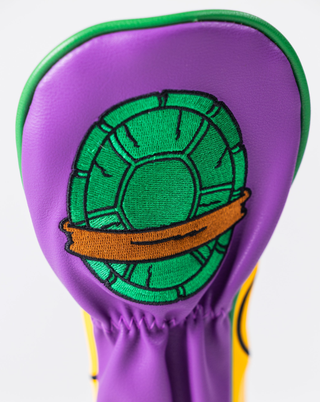 Donatello hybrid golf headcover featuring a vibrant purple design with a turtle shell emblem and orange band.