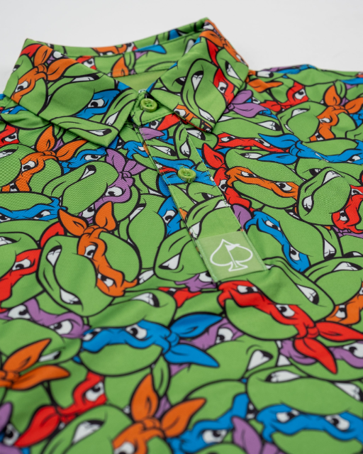 Colorful youth polo featuring a vibrant print of Teenage Mutant Ninja Turtles' faces in green, orange, and purple.