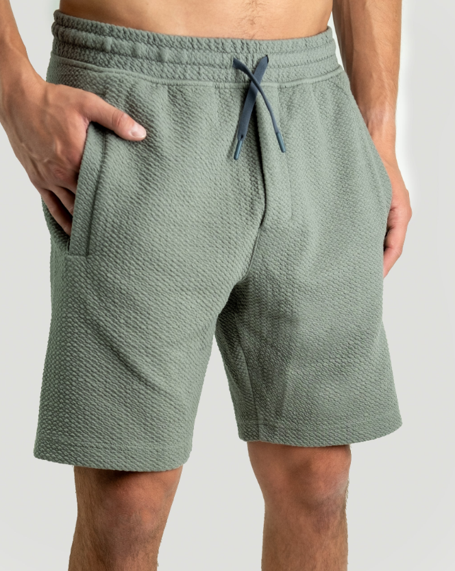 Sage waffleknit shorts with an elastic waistband and drawstring, featuring side pockets for a comfortable fit.