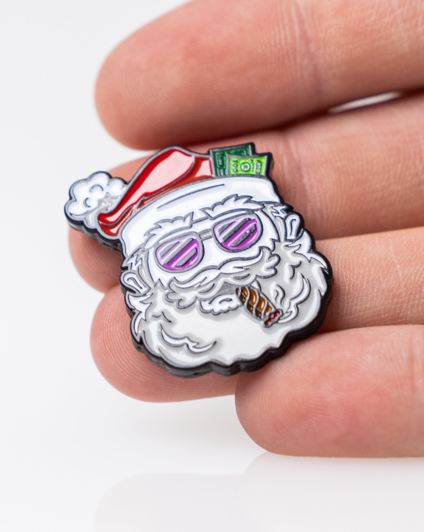 Colorful Santa-themed ball marker featuring sunglasses, a cigar, and cash tucked in his hat, held between fingers.