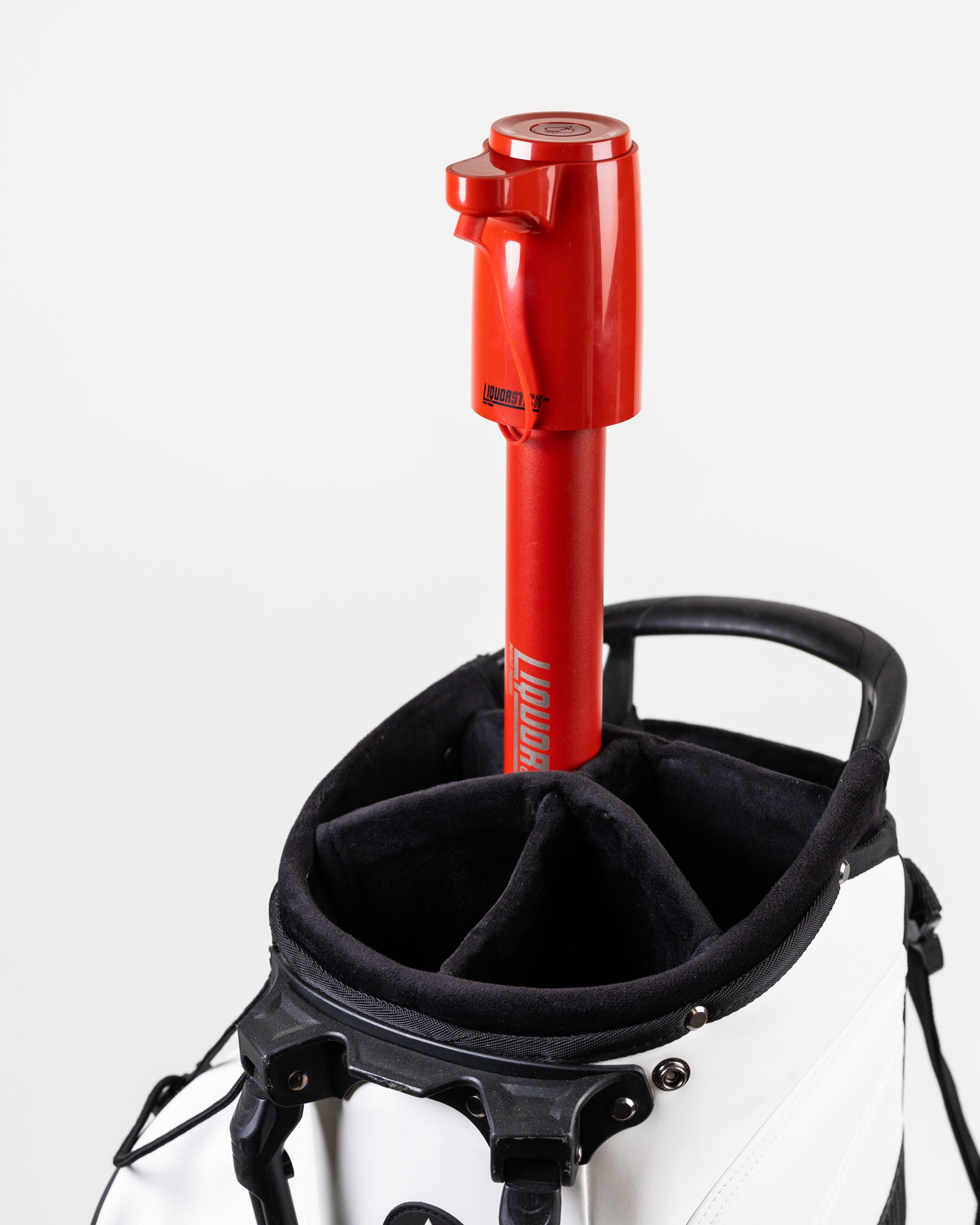 Red LiquorStick® 2.0 mounted on a golf bag, designed for easy access to beverages on the course.
