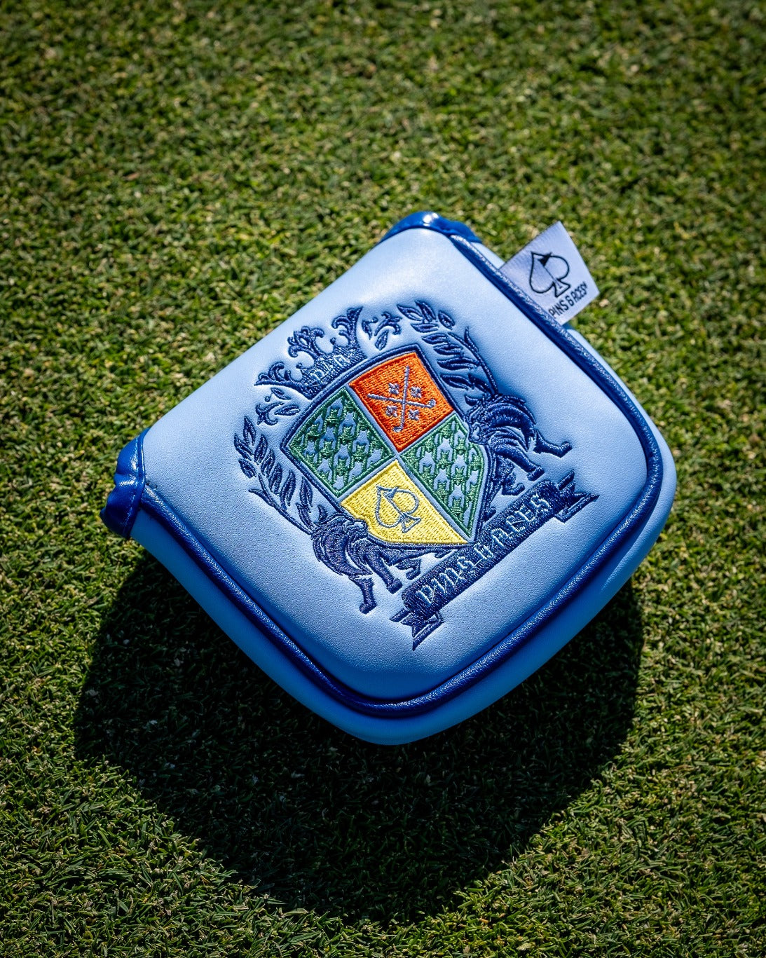 Bold blue mallet cover featuring an intricate coat of arms design, perfect for golfers seeking unique accessories.