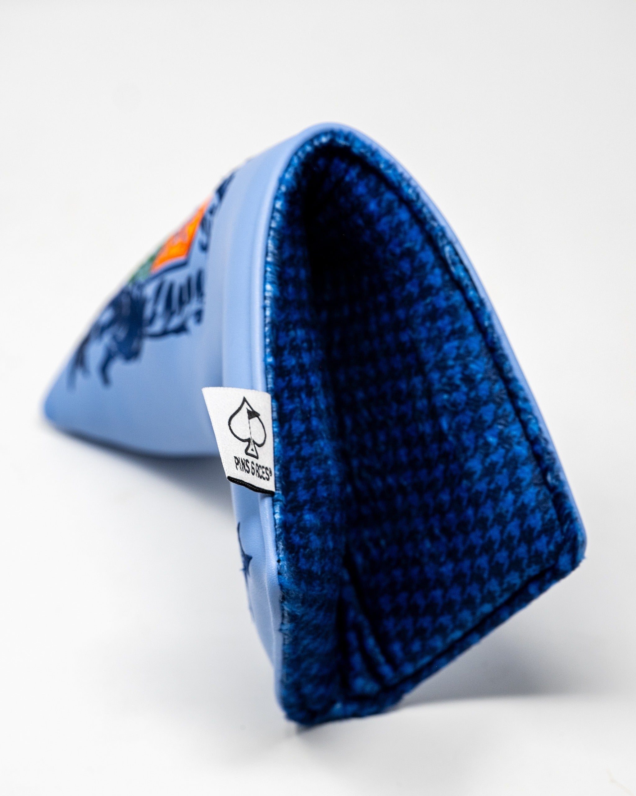 Blade putter cover featuring a vibrant coat of arms design, with a blue interior and Pins and Aces branding tag.