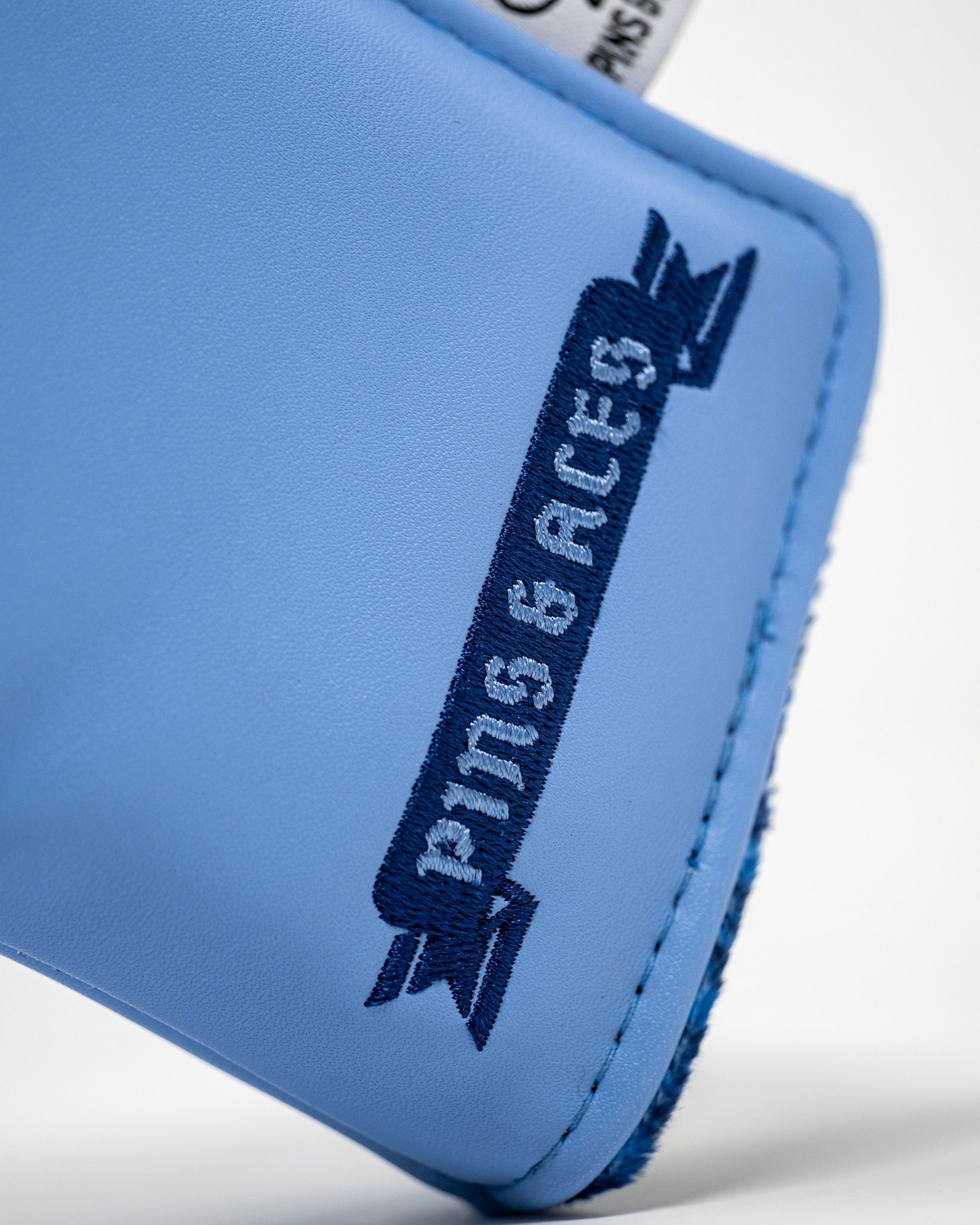 Blue blade putter cover featuring a bold "Pins & Aces" logo, designed for golfers seeking unique style on the course.