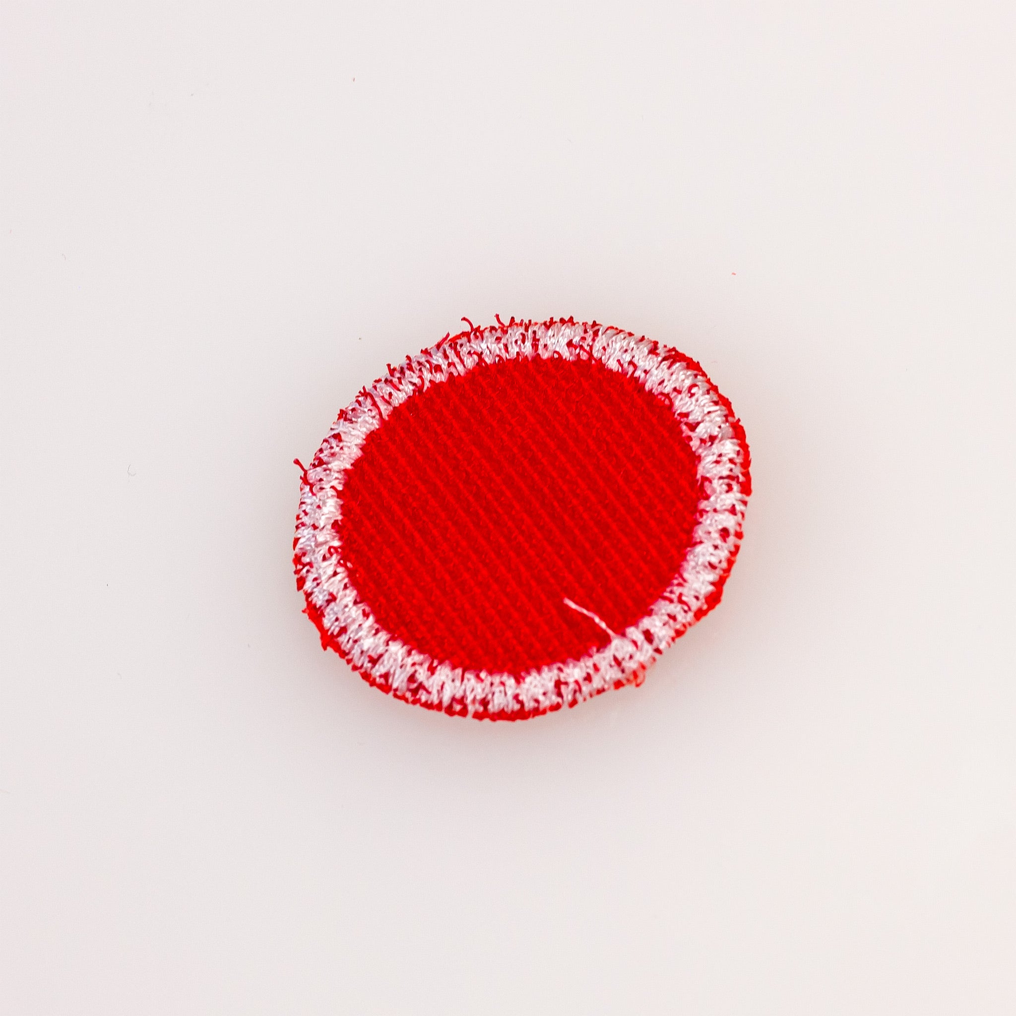 Red headcover patch with a textured surface and white border, designed to personalize golf accessories.